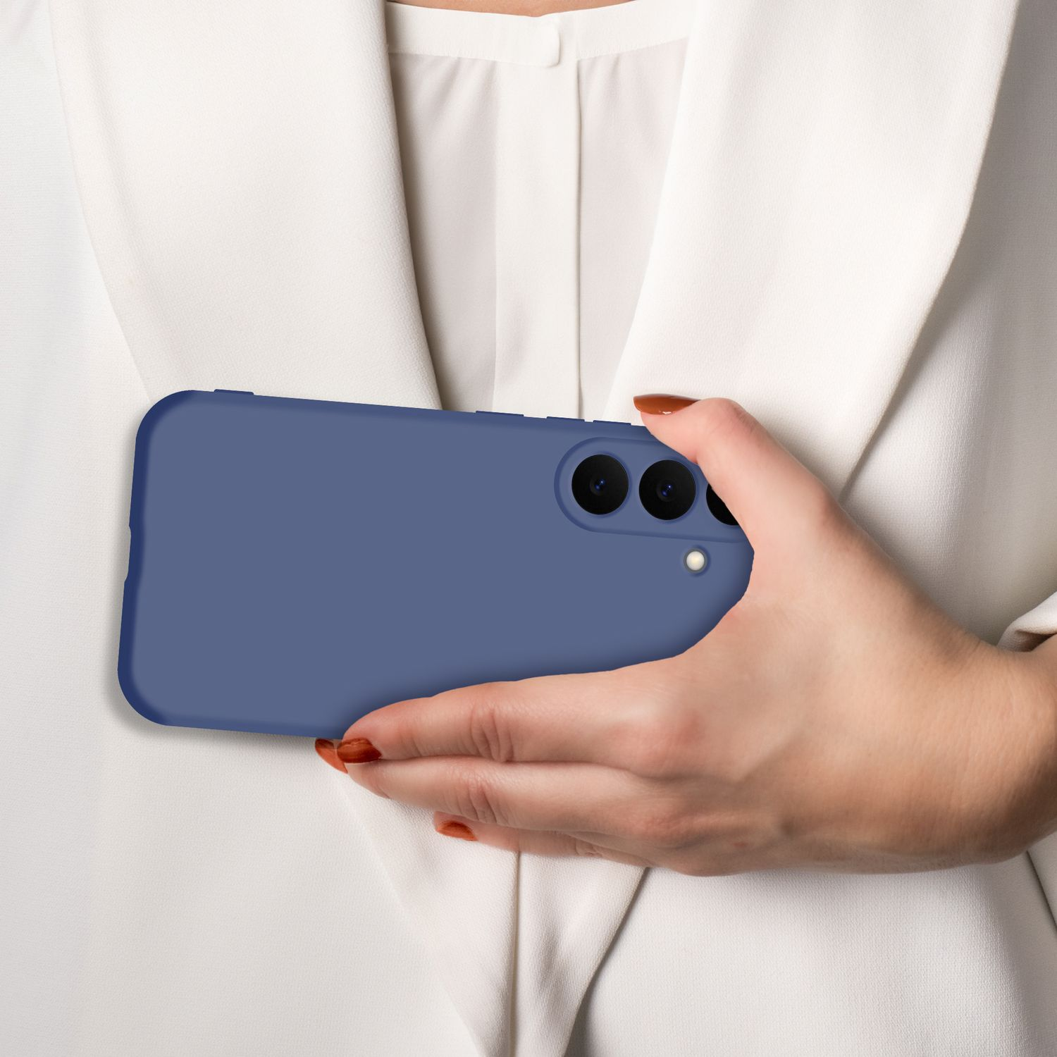 Eine Hand hält ein blaues Smartphone vor einem weißen Hemd.