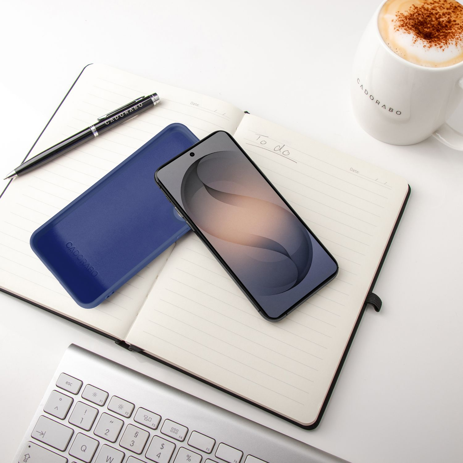 Notizbuch mit Stift, Handy, Tastatur und Kaffee. 'To do' im Notizbuch.