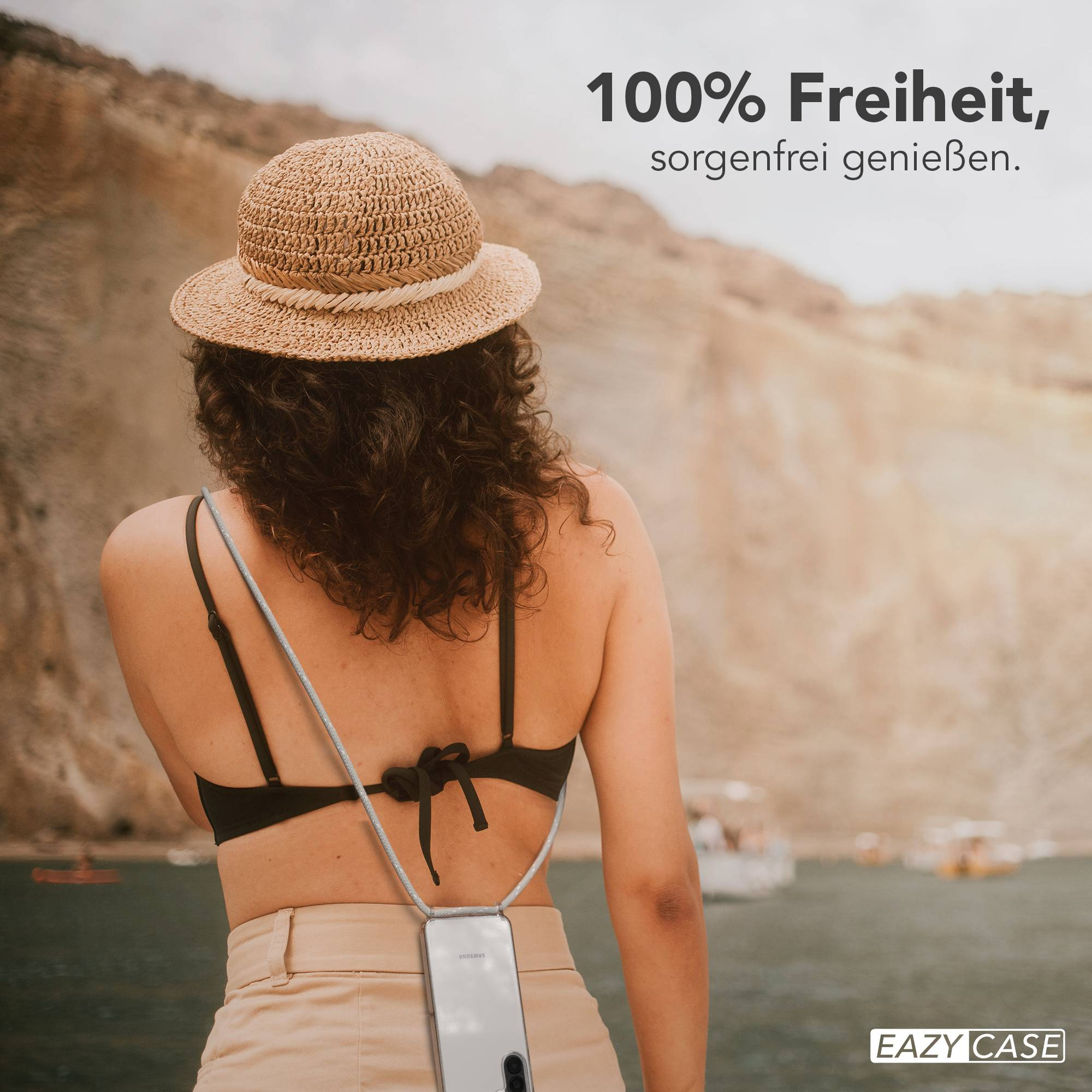 Frau mit Strohhut und Smartphone-Halterung am See