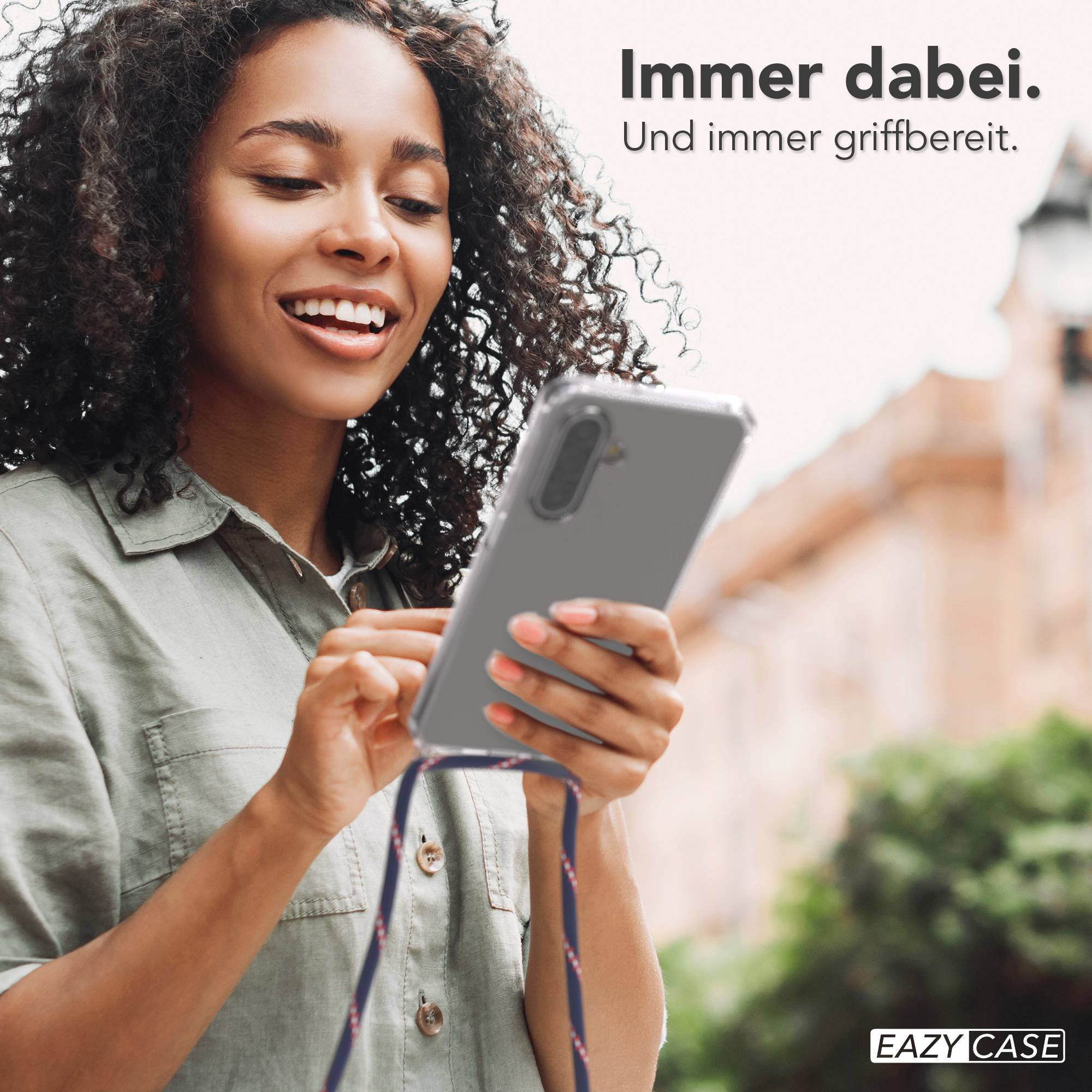 Eine Frau mit lockigem Haar hält ein transparentes Handy mit einem Band.