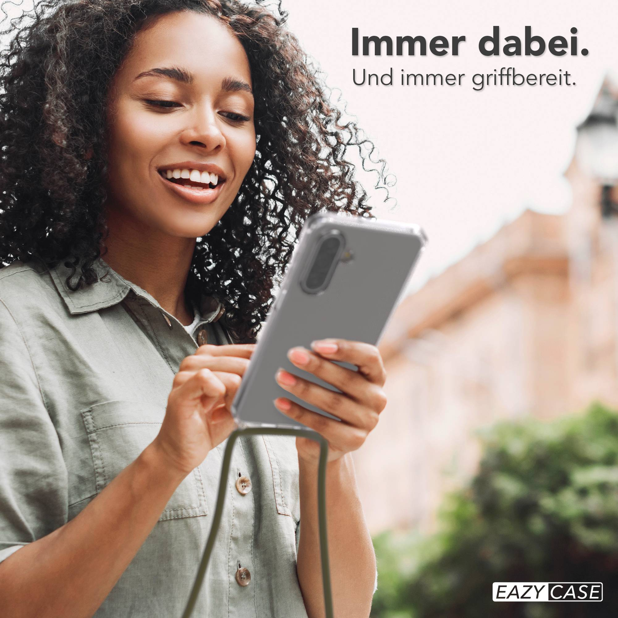 Eine Frau mit lockigen Haaren hält ein Smartphone mit einer Schutzhülle.