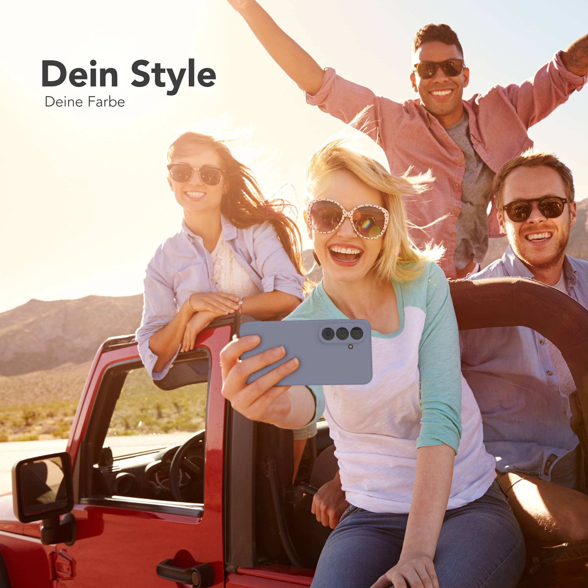 Vier Freunde in einem roten Jeep, eine Frau macht ein Selfie mit einem Handy.