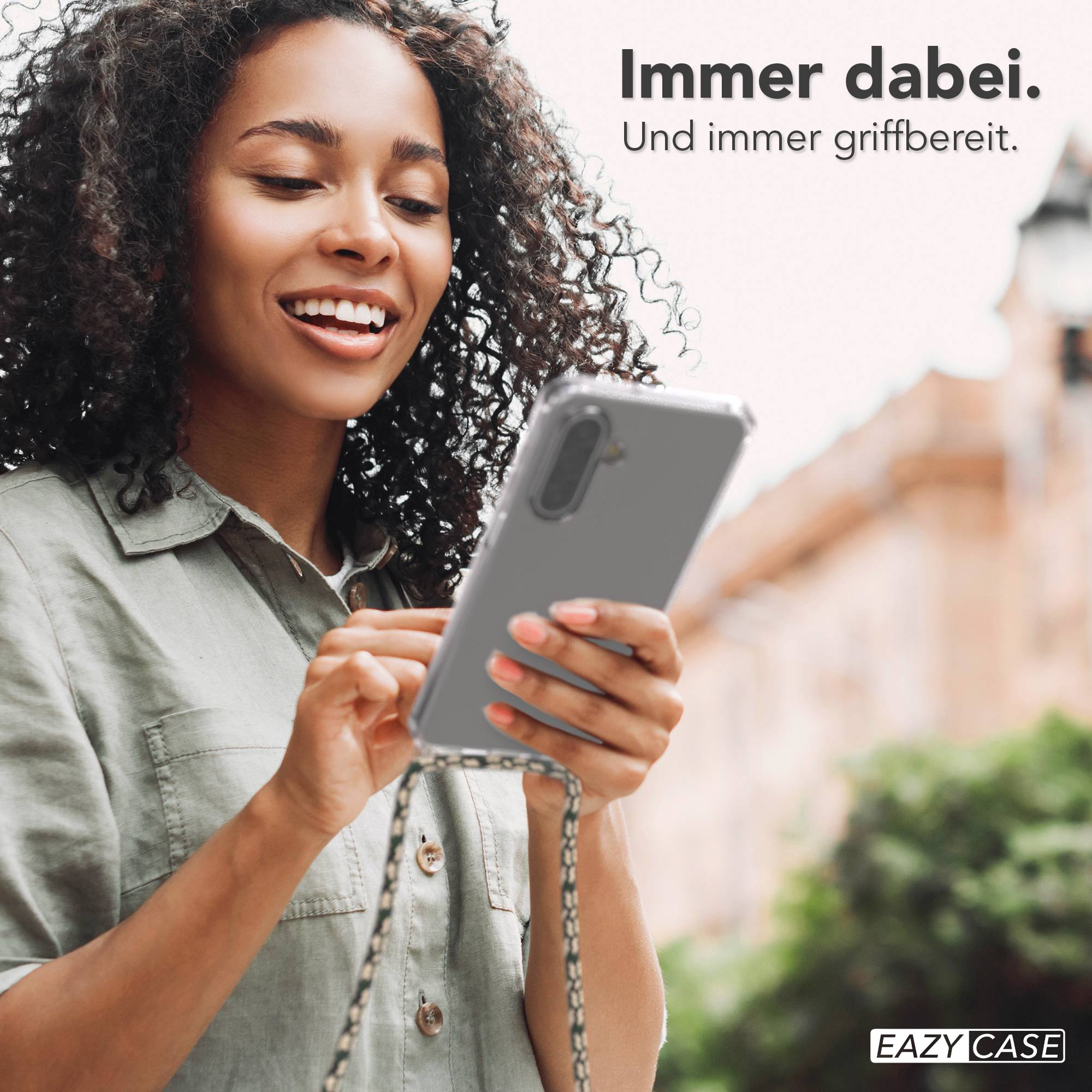 Eine Frau hält ein Smartphone mit durchsichtiger Hülle und Schnur.