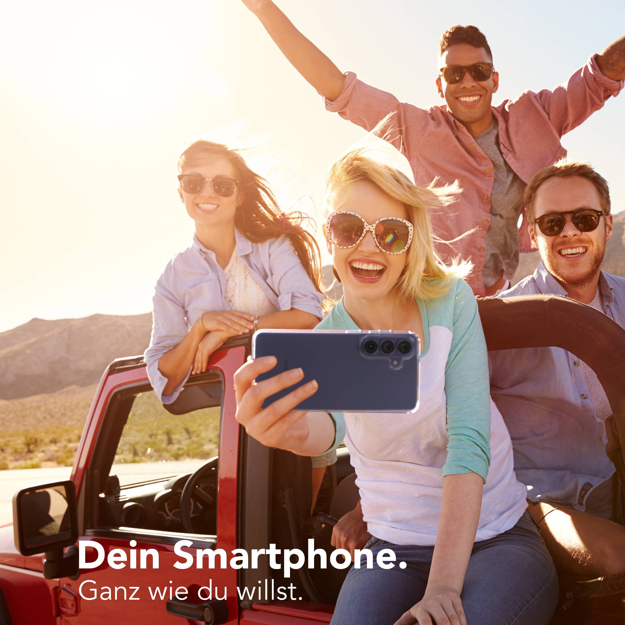 Freunde im Jeep machen ein Selfie mit einem Smartphone, sie lachen und winken.