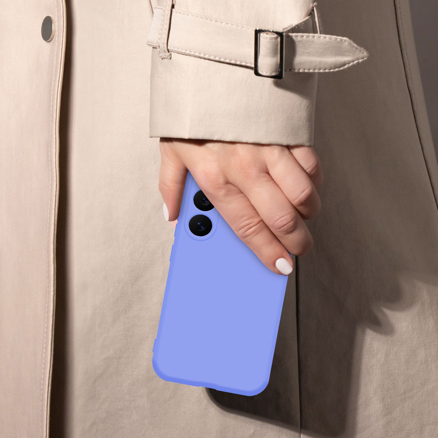 Eine Hand hält ein lavendelfarbenes Smartphone vor einem beigen Trenchcoat.