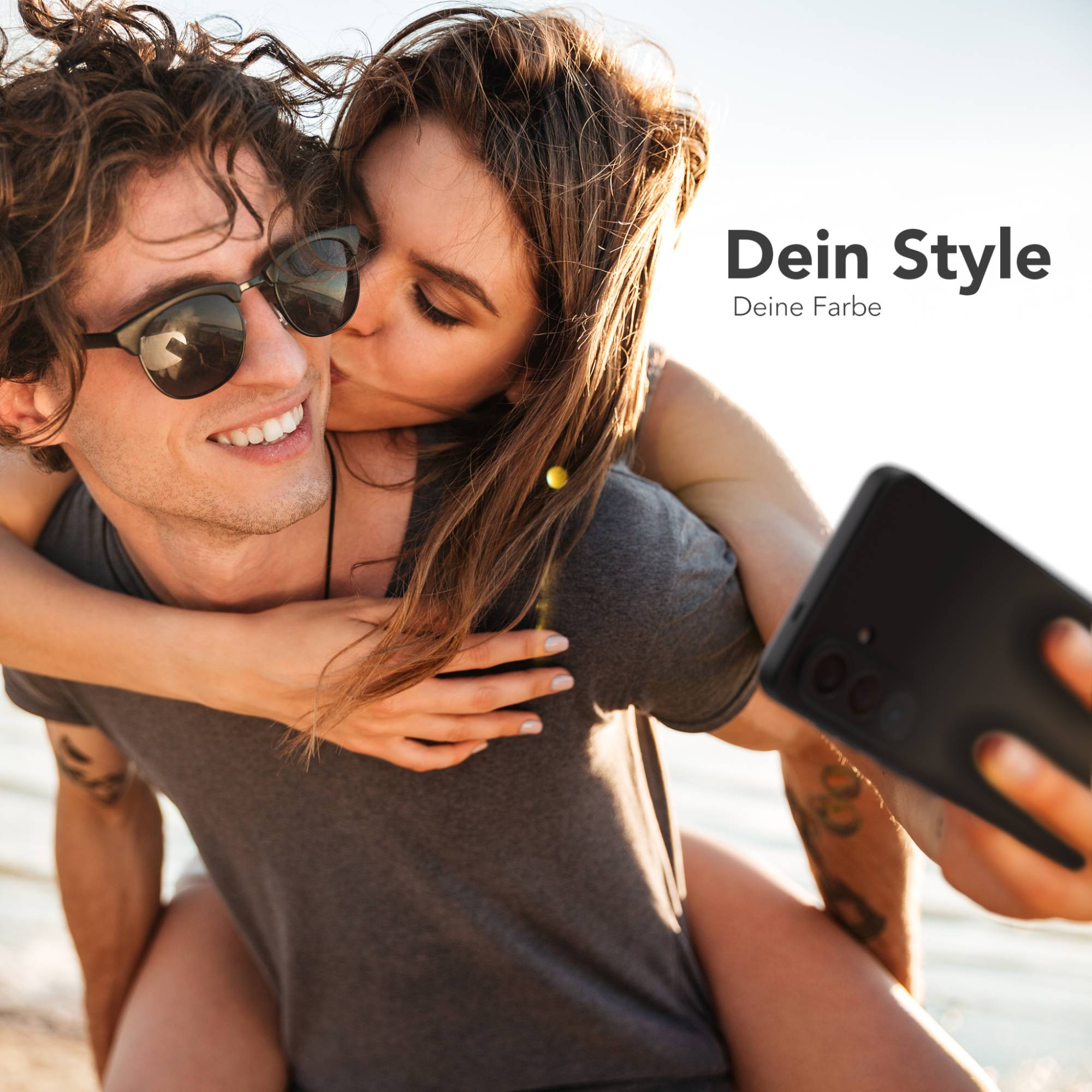 Ein Mann mit Sonnenbrille und eine Frau küssen ihn, während sie ein Selfie machen.