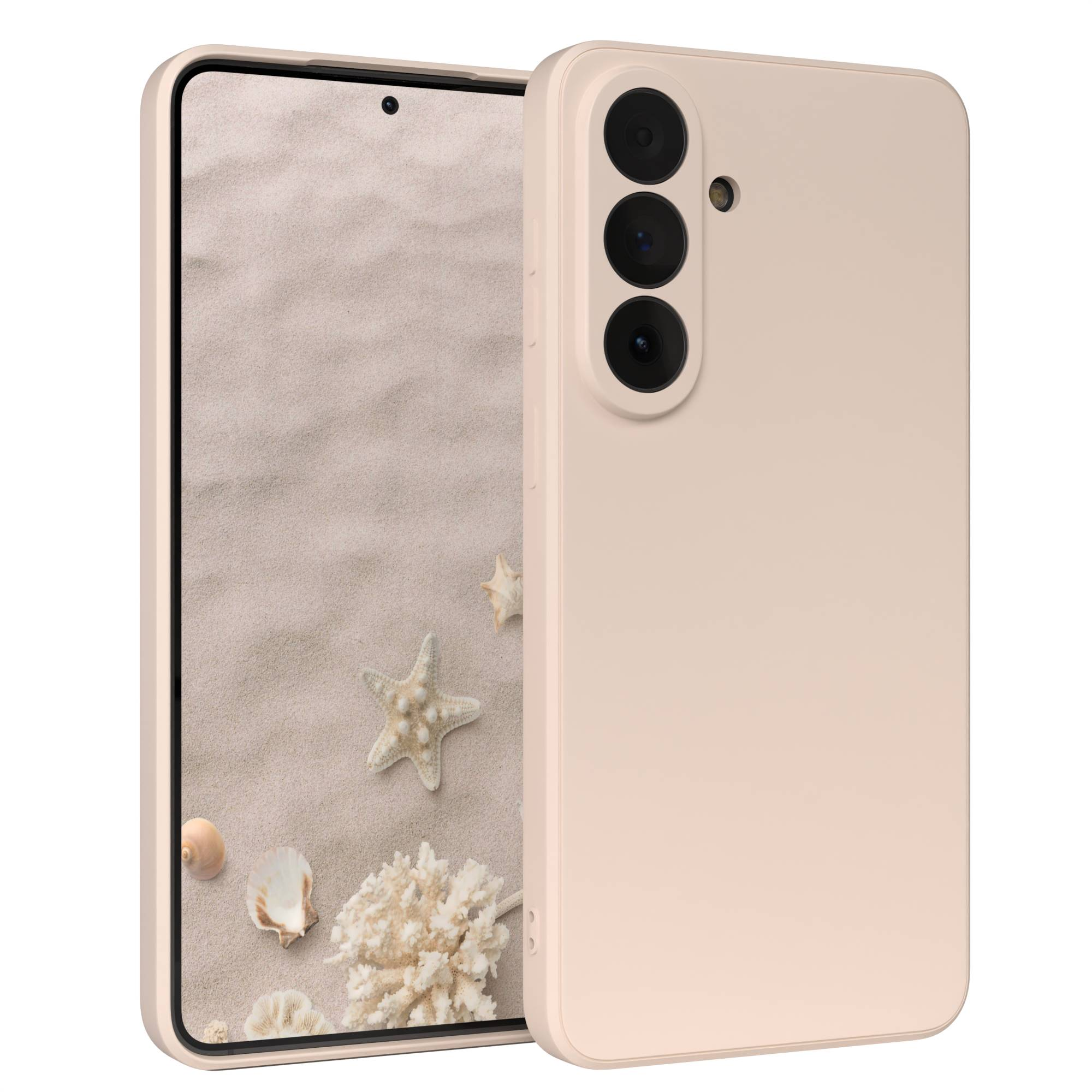Ein hellrosa Handy mit drei Kameras auf der Rückseite, daneben ein Display mit Sand und Muscheln.