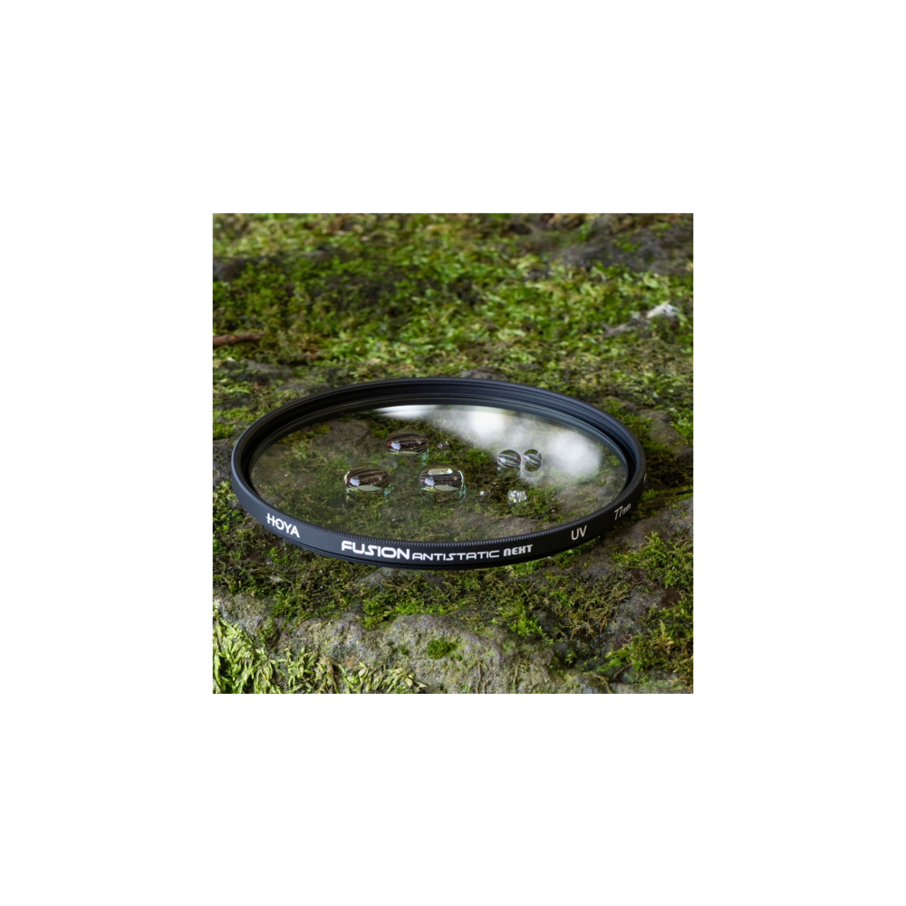 Ein Hoya UV-Filter mit Wassertropfen auf moosbewachsenem Stein.