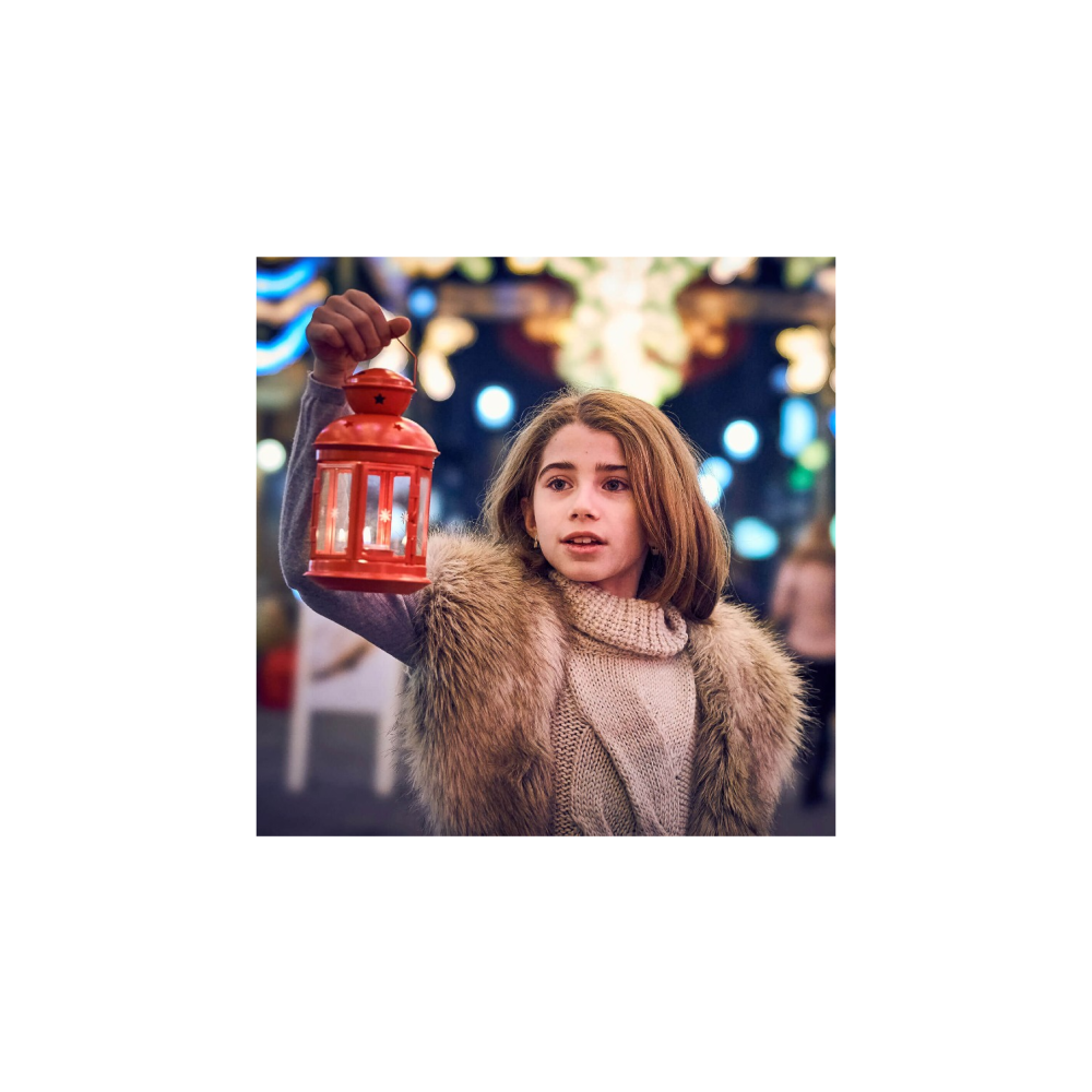 A girl holds a red lantern. She wears a fur vest and a sweater.