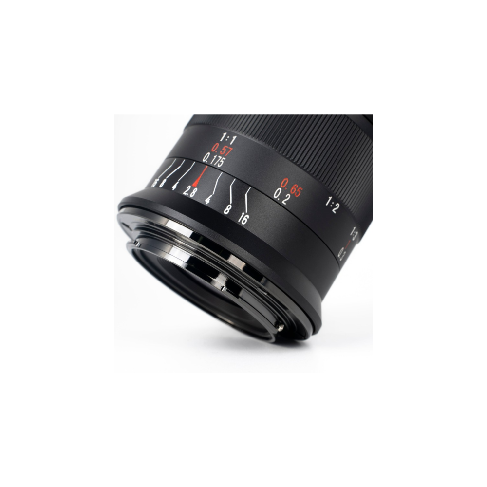Close-up of a black camera lens with focus and aperture markings.