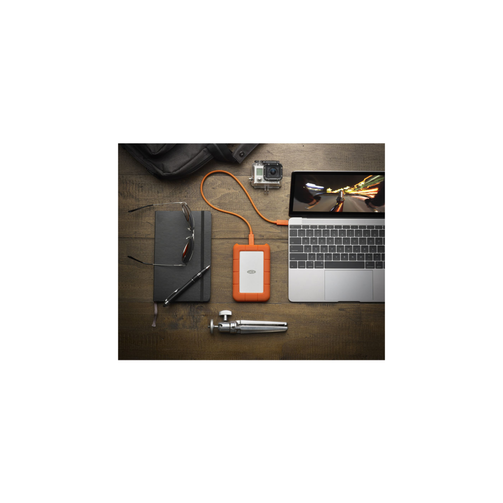 Laptop, dysk zewnętrzny, GoPro i notatnik na drewnie.