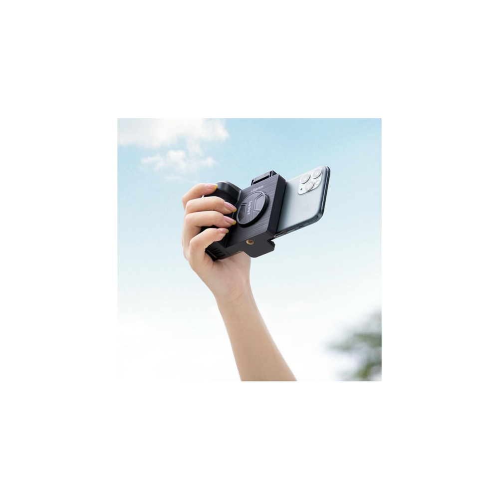 Hand houdt smartphone camera-accessoire tegen blauwe lucht.