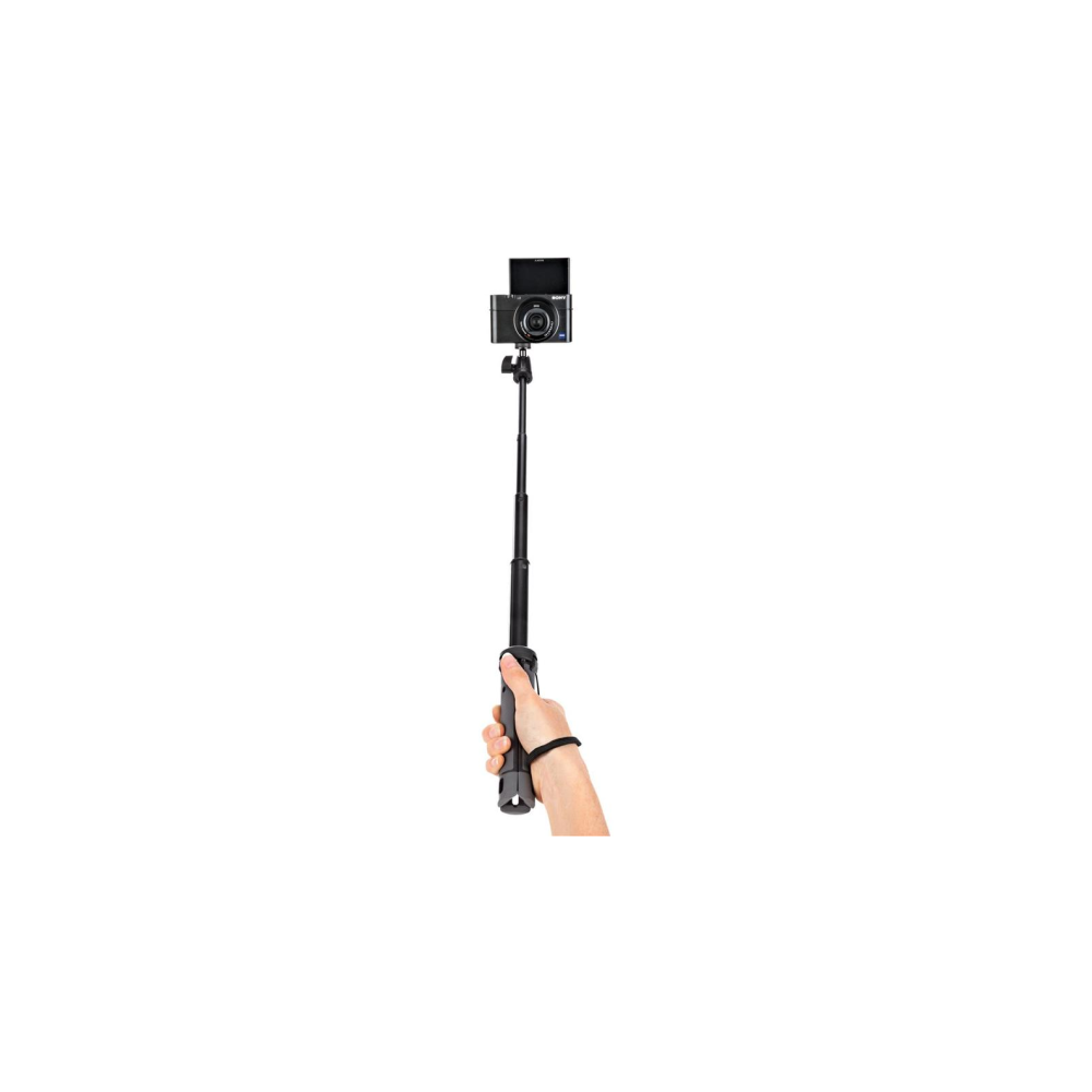 Hand holding extendable selfie stick with camera on white background.