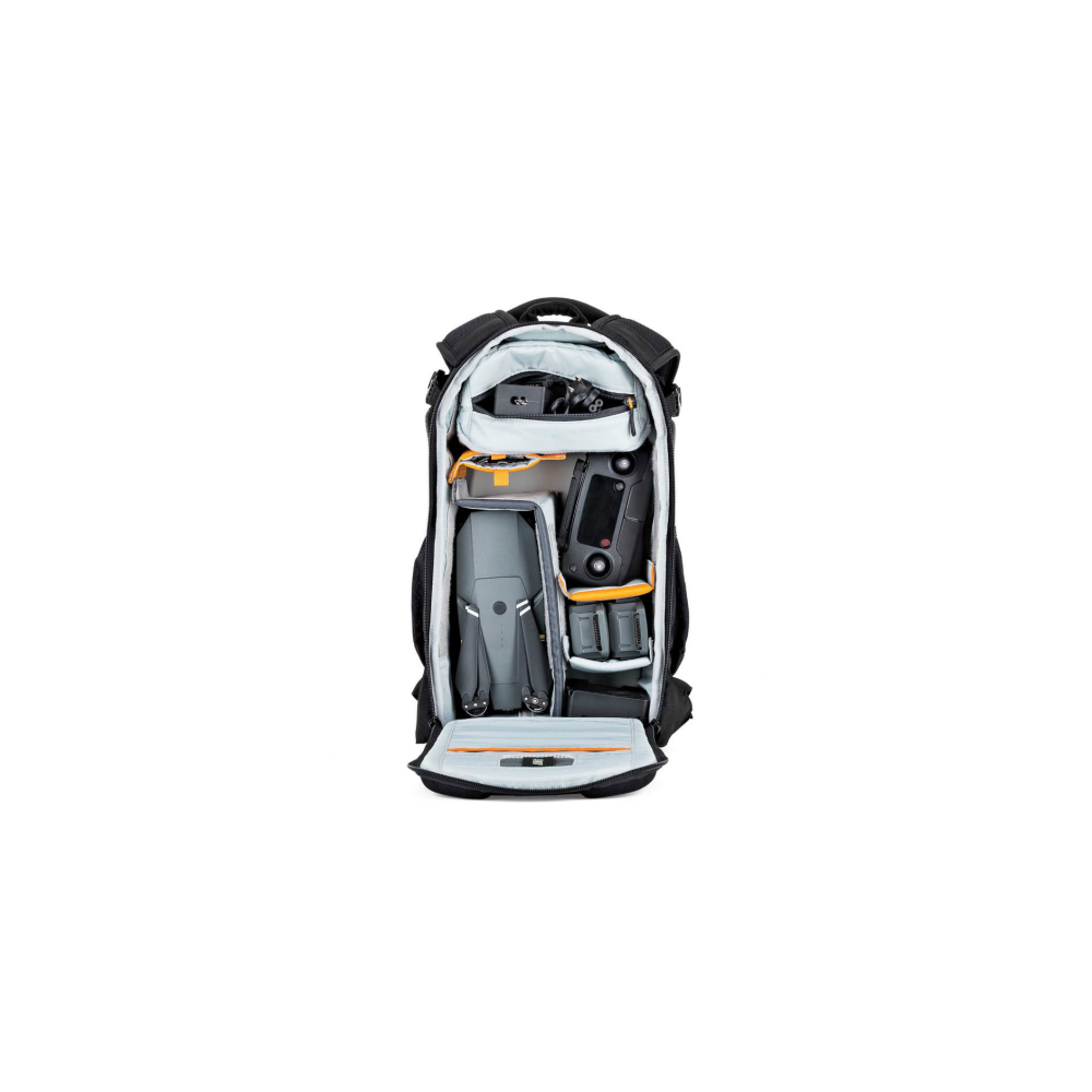 A black backpack is open, showing a grey drone, controller, and batteries inside.