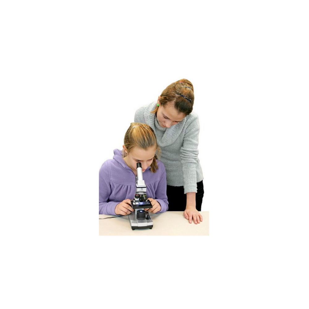 Dos niñas miran juntas un microscopio sobre una mesa.