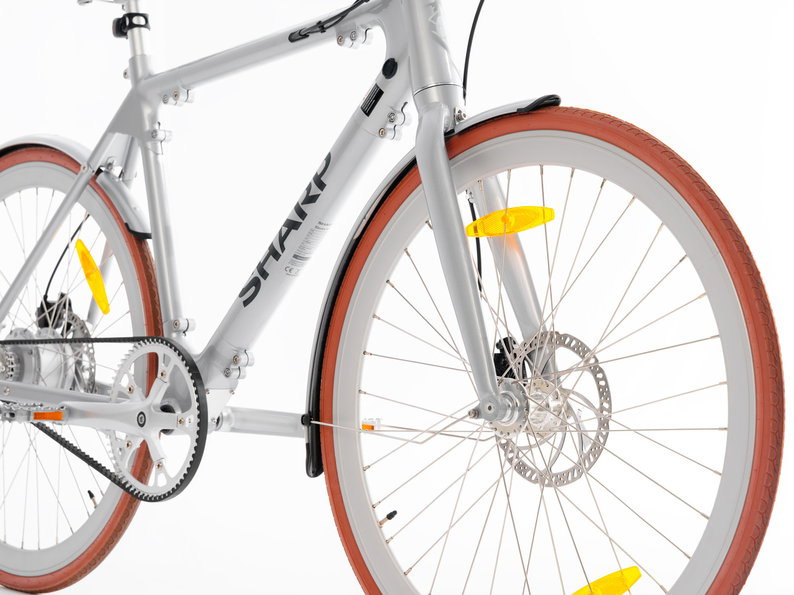 Silbernes Fahrrad mit braunen Reifen, Zahnriemen und Scheibenbremsen.