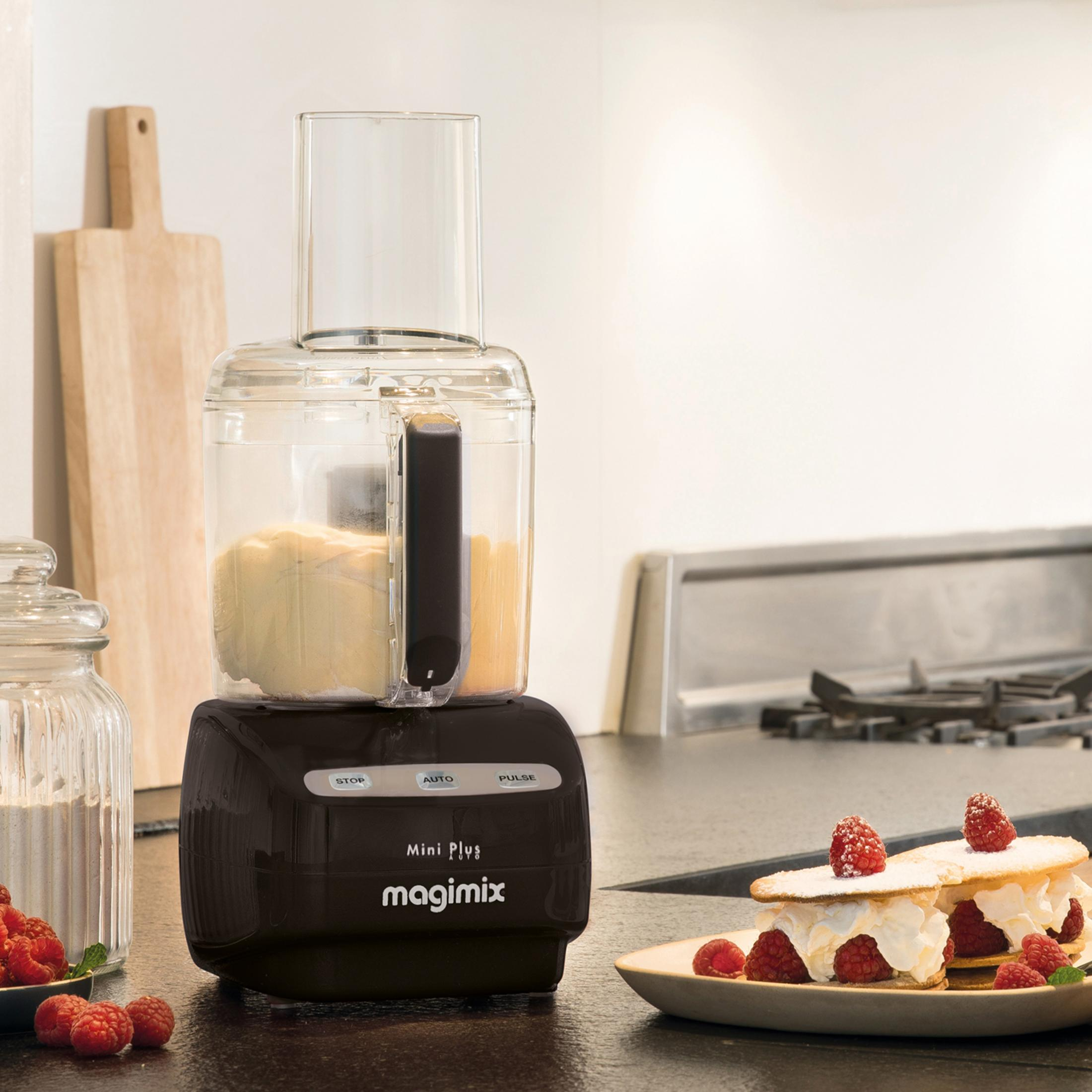 Een zwarte Magimix keukenmachine met deeg en frambozendesserts.