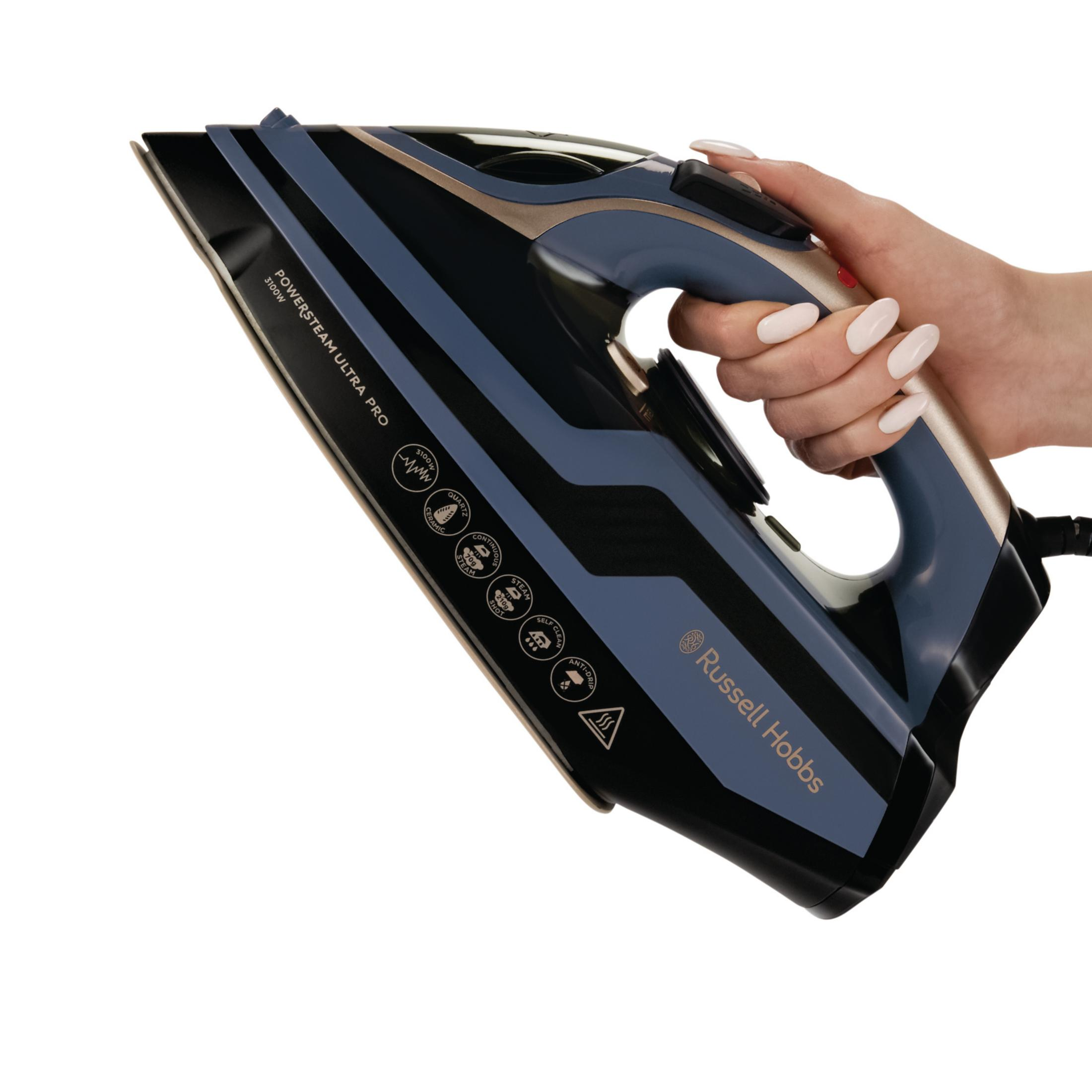 Eine Hand hält ein blau-schwarzes Dampfbügeleisen mit goldenen Akzenten.