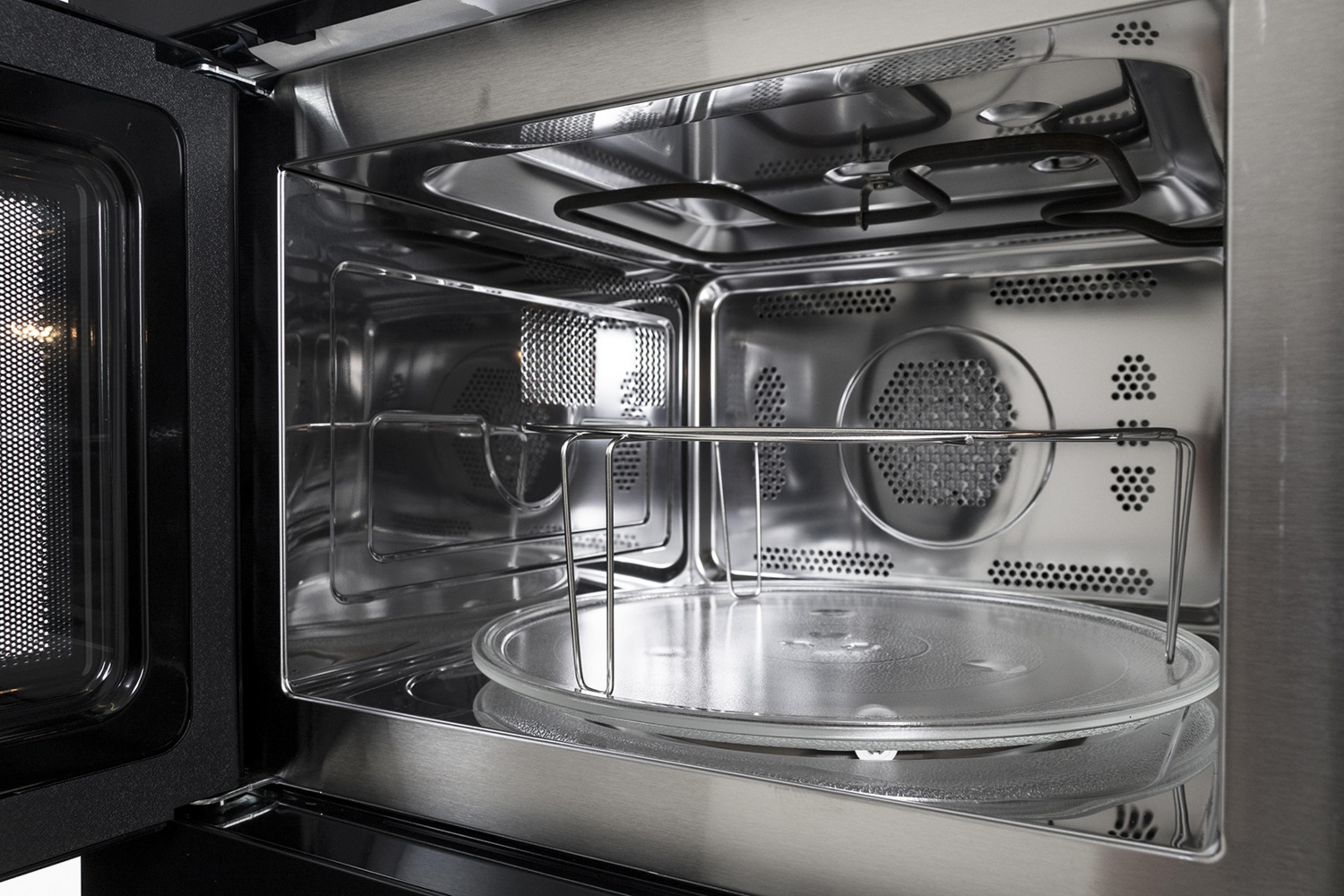 Interior of a microwave oven with a glass turntable and heating elements.