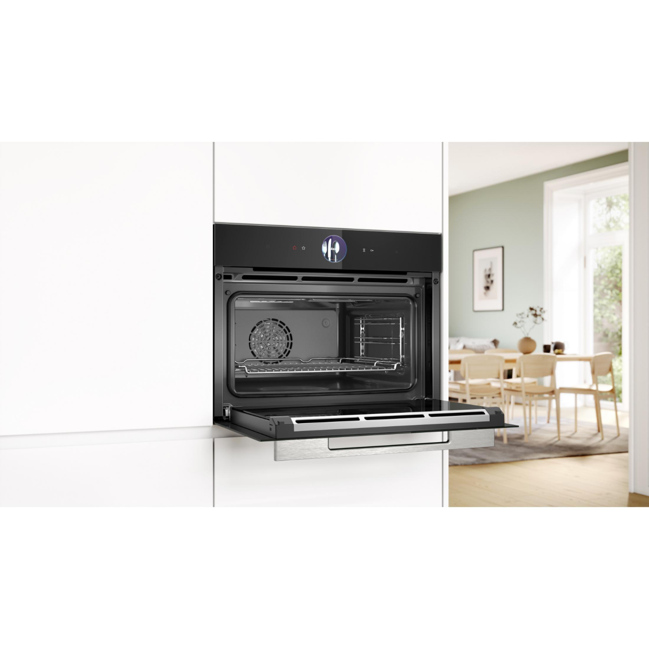 Un forno da incasso moderno con porta aperta mostra l'interno con griglia e ventola.