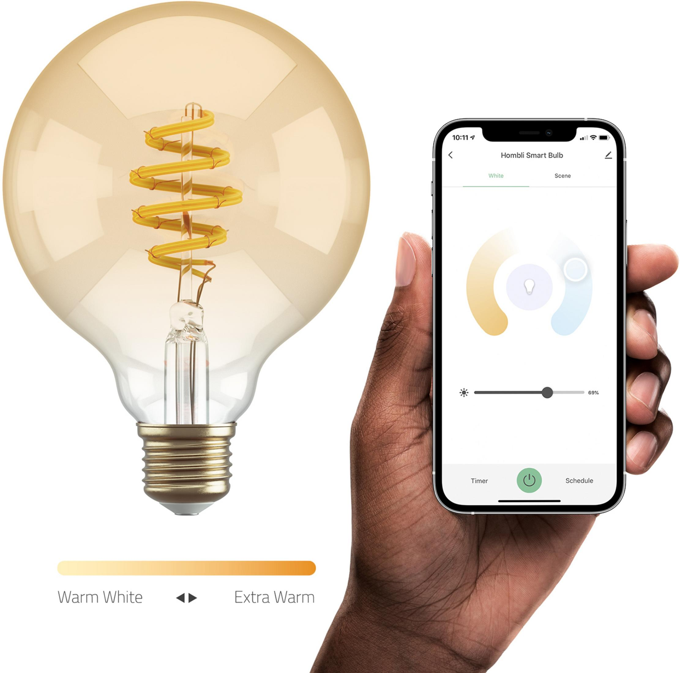 Une main tient un smartphone avec une application d'ampoule à côté d'une grande ampoule blanc chaud.