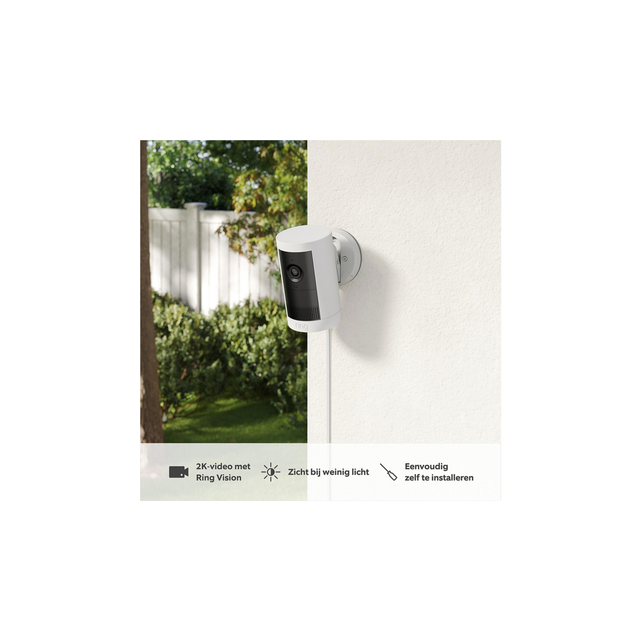 Una telecamera Ring bianca con parte anteriore nera è montata su un muro.
