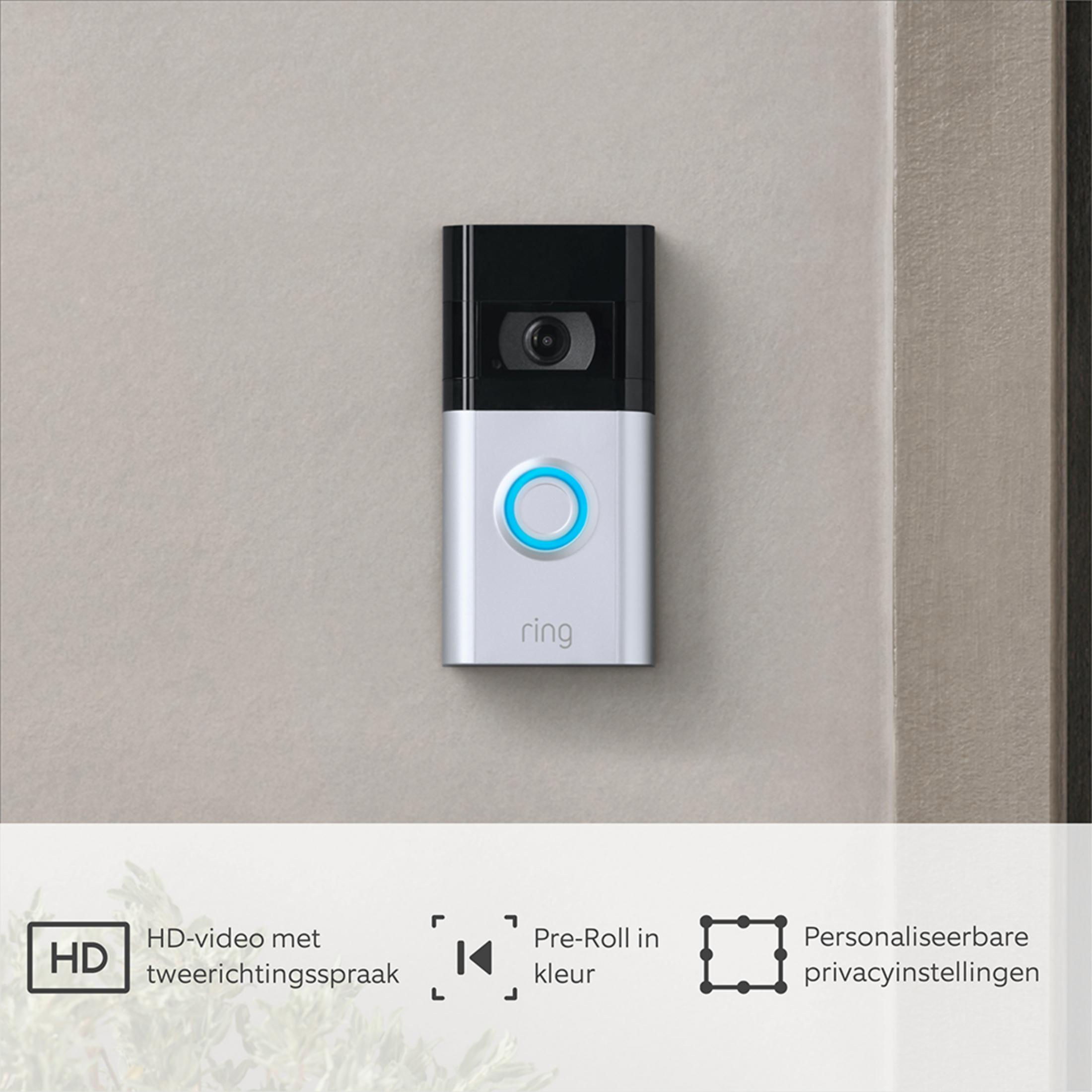 Ein Ring-Türklingel mit Kamera und blauem Licht an einer Wand.