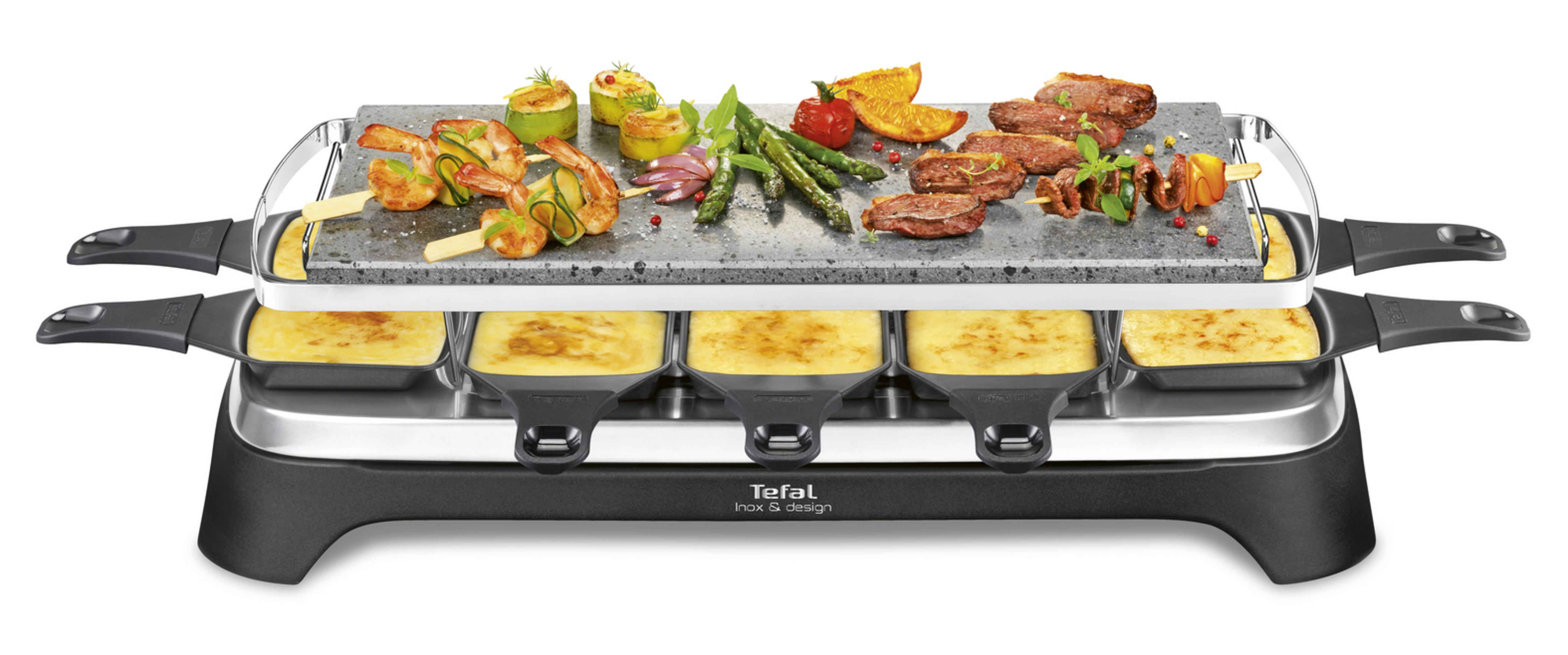Ein Raclettegerät mit gegrilltem Fleisch, Garnelen, Gemüse und geschmolzenem Käse.