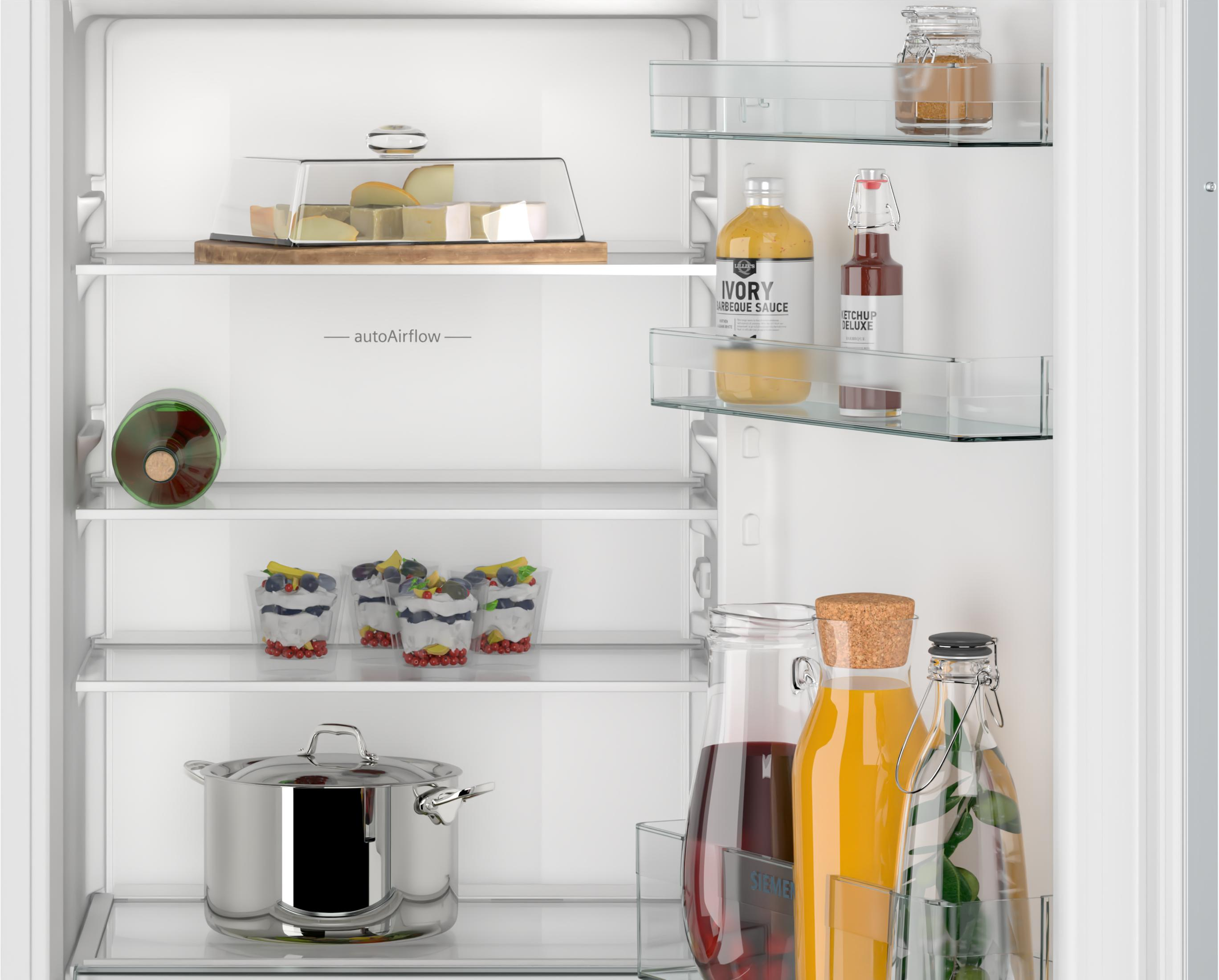 Refrigerator interior with cheese, sauces, desserts, a pot, and drinks.