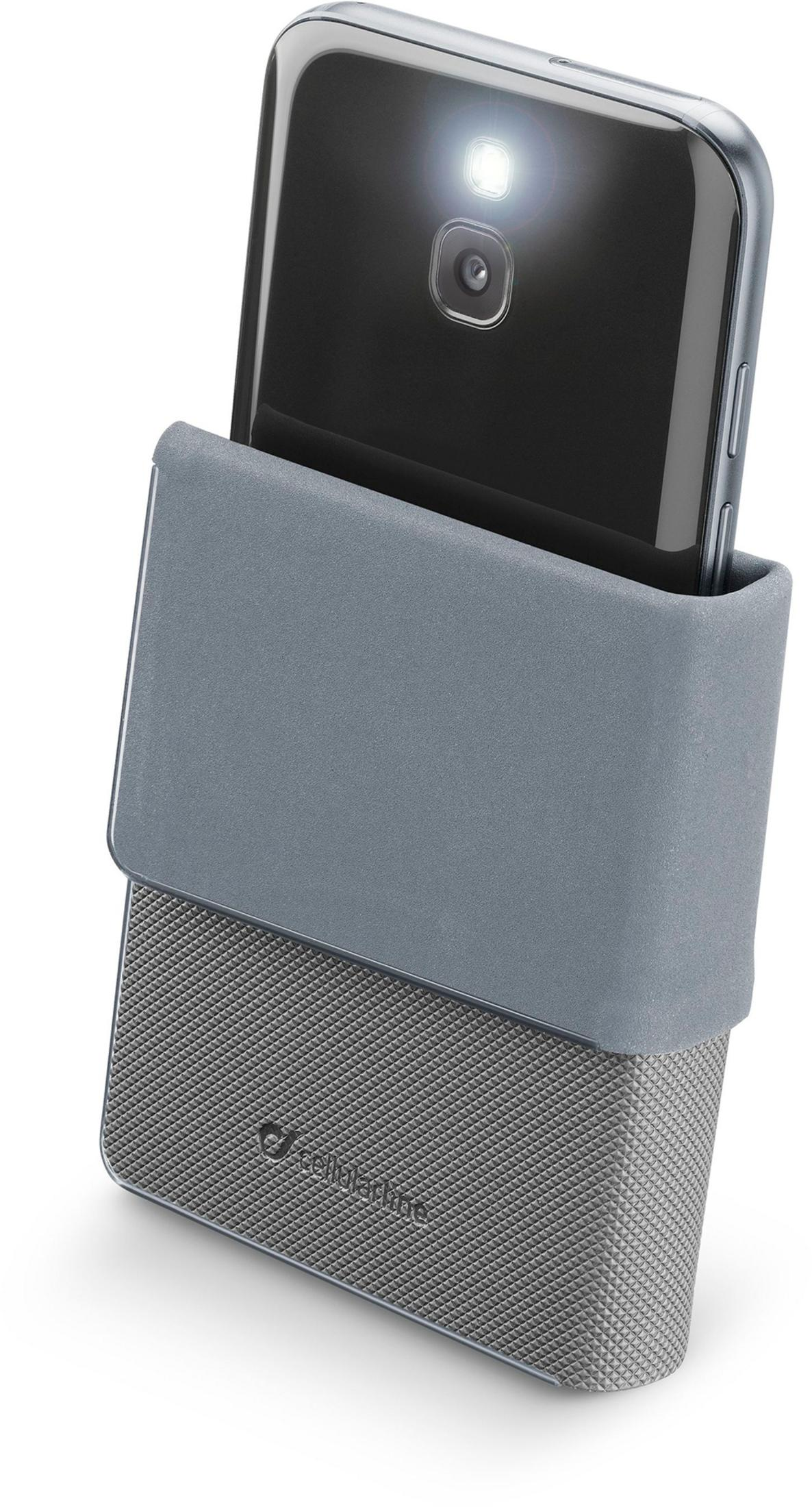 Un smartphone con el flash encendido está sujeto en una funda gris.