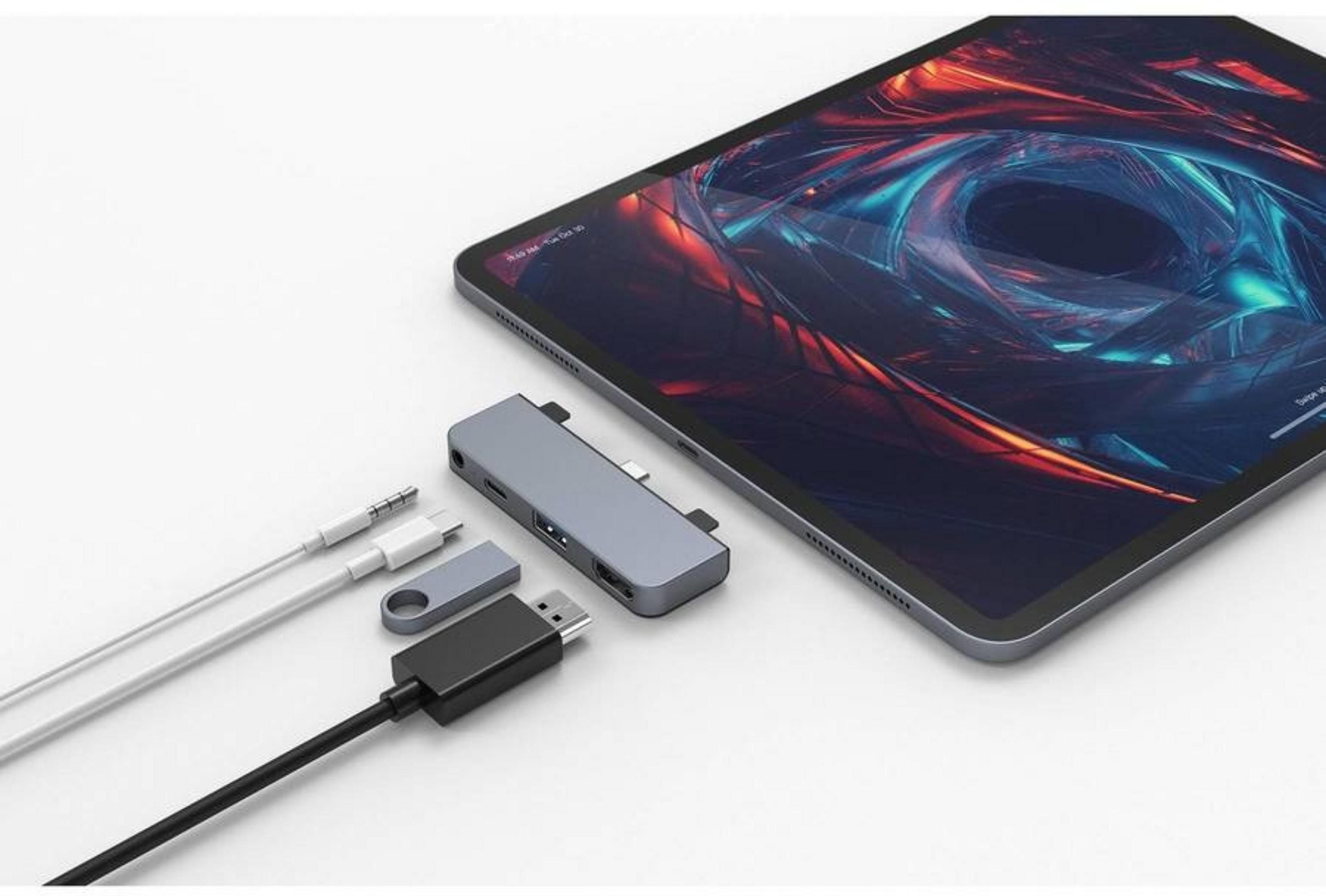Una tableta con fondo abstracto y un hub USB-C con cables al lado.