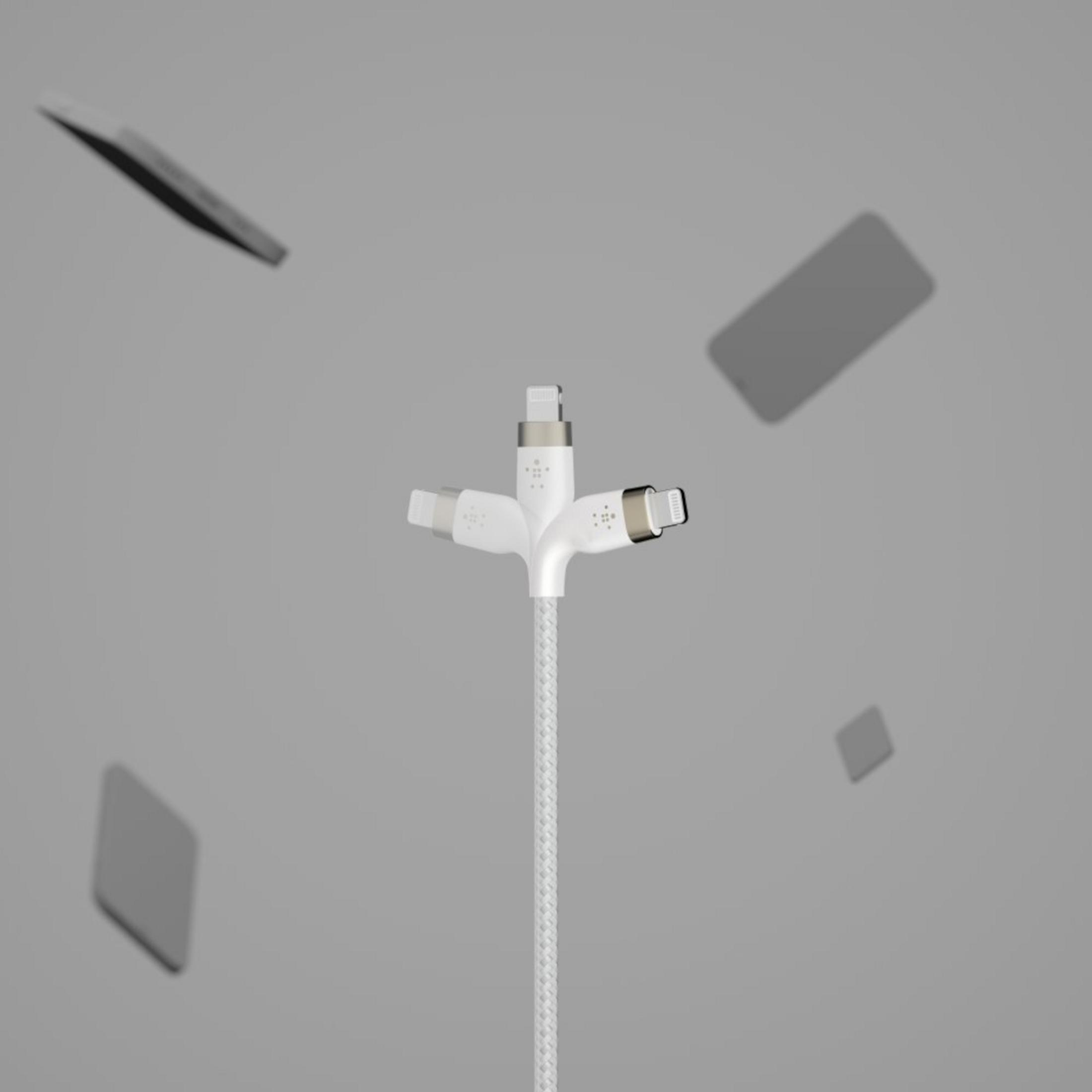 Biały kabel ładujący z trzema złączami, otoczony unoszącymi się smartfonami.