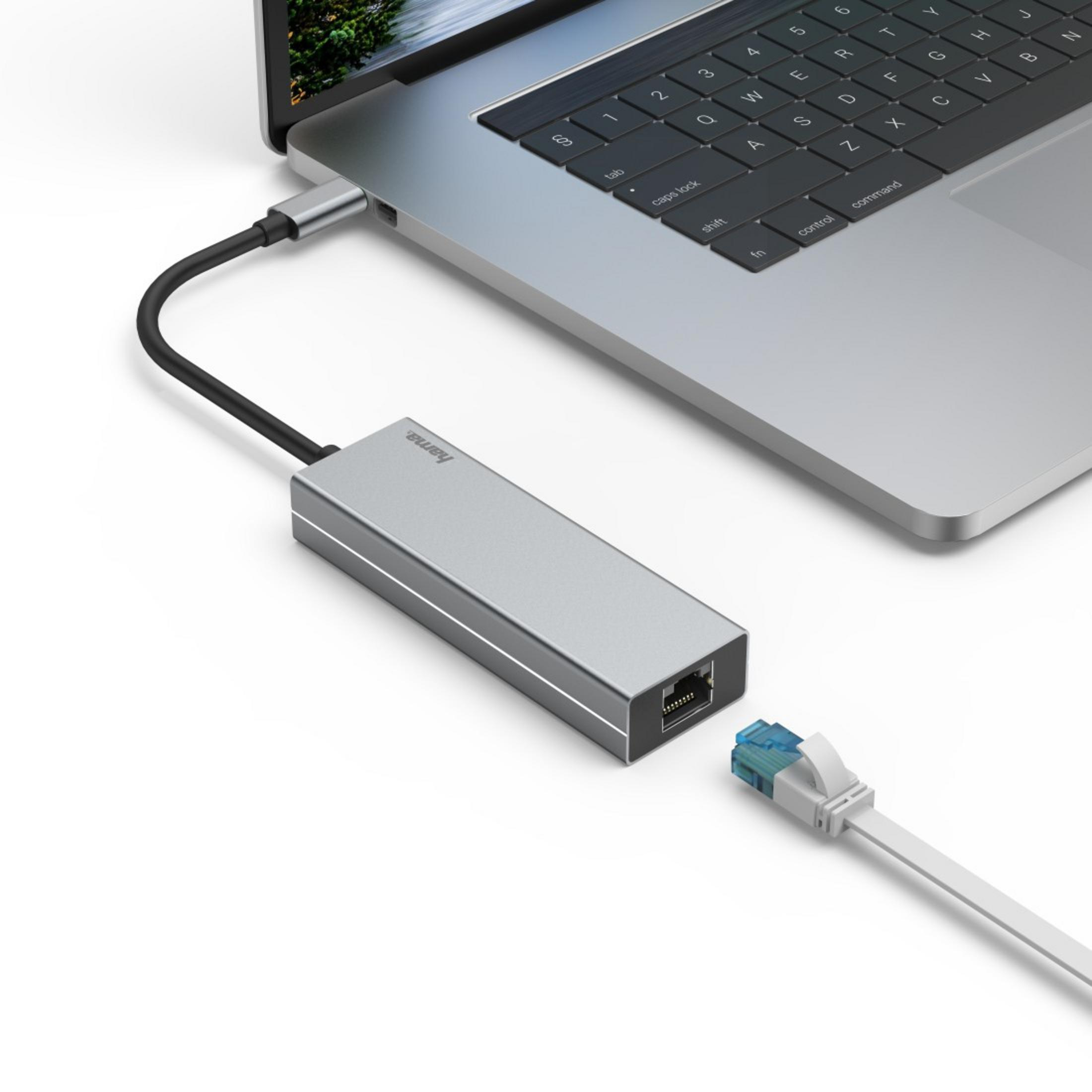 Srebrny adapter USB-C z kablem Ethernet, podłączony do laptopa.