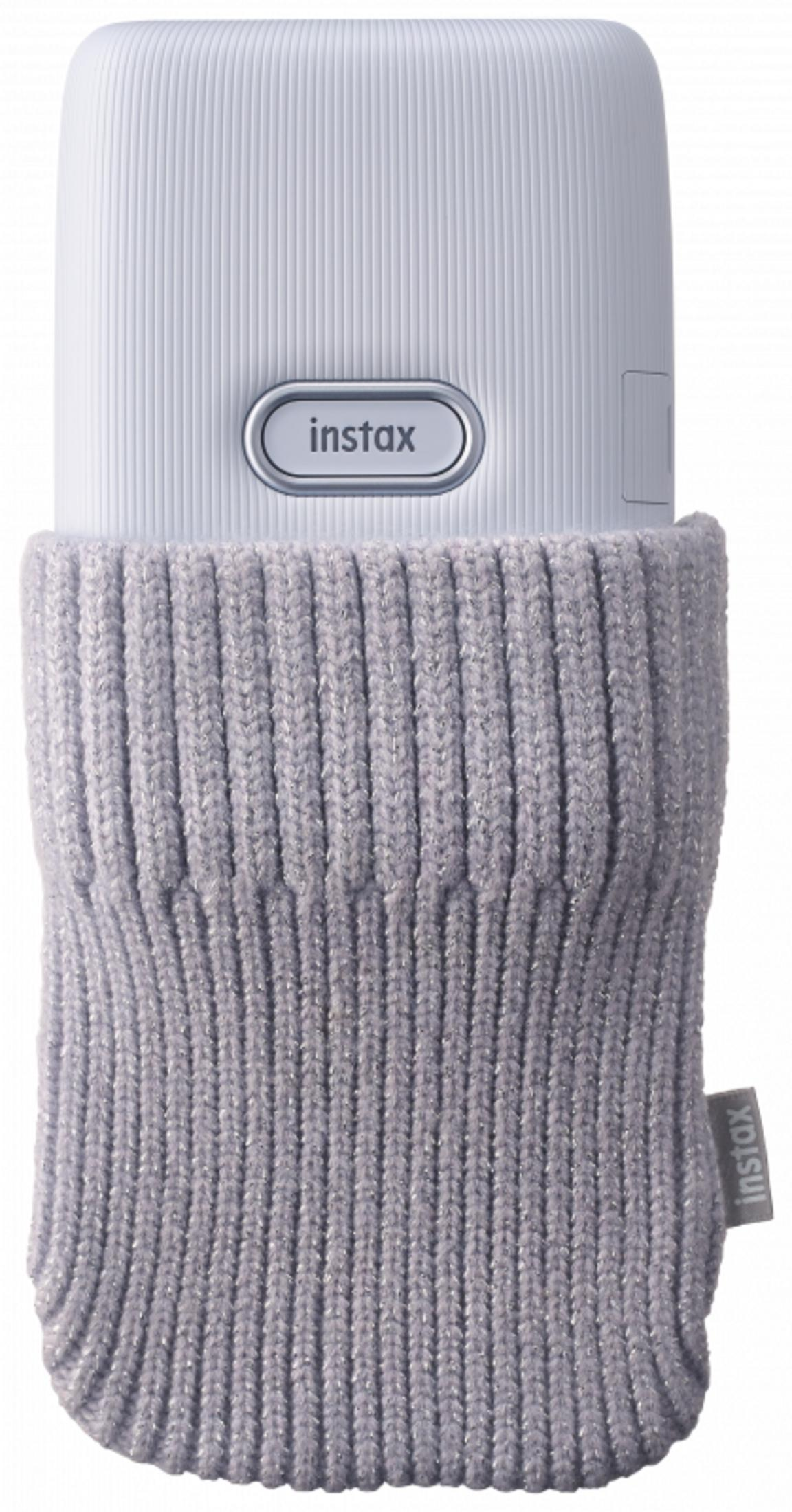 Gümüş ipli gri örgü kılıflı beyaz Instax kamera.