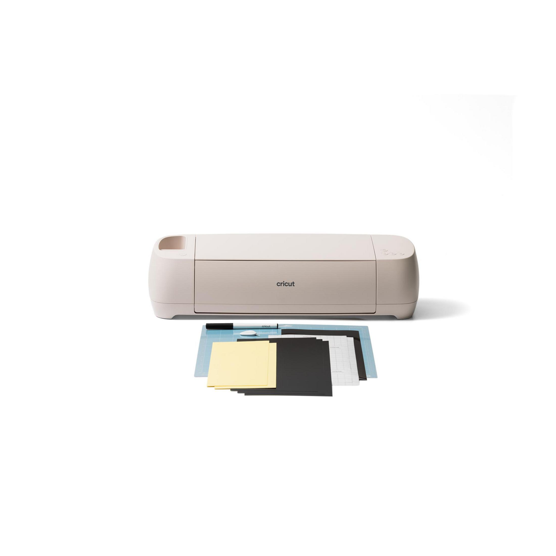 Ein beiger Schneideplotter mit Materialien wie Papier und einer Matte.