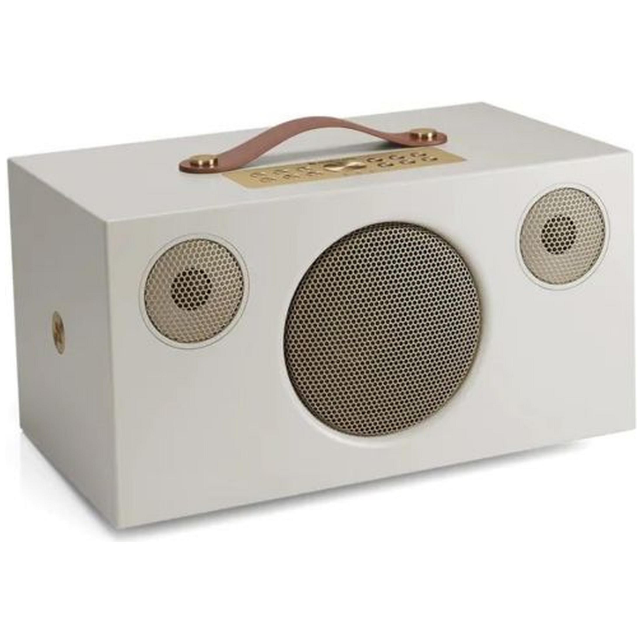 Een witte luidspreker met bruine handgreep en gouden accenten.