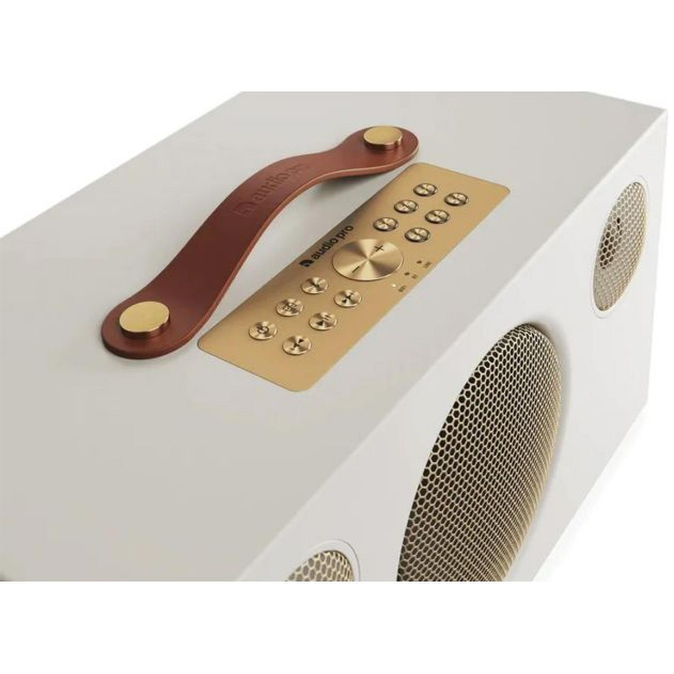 Een witte luidspreker met bruine leren handgreep en gouden afstandsbediening.
