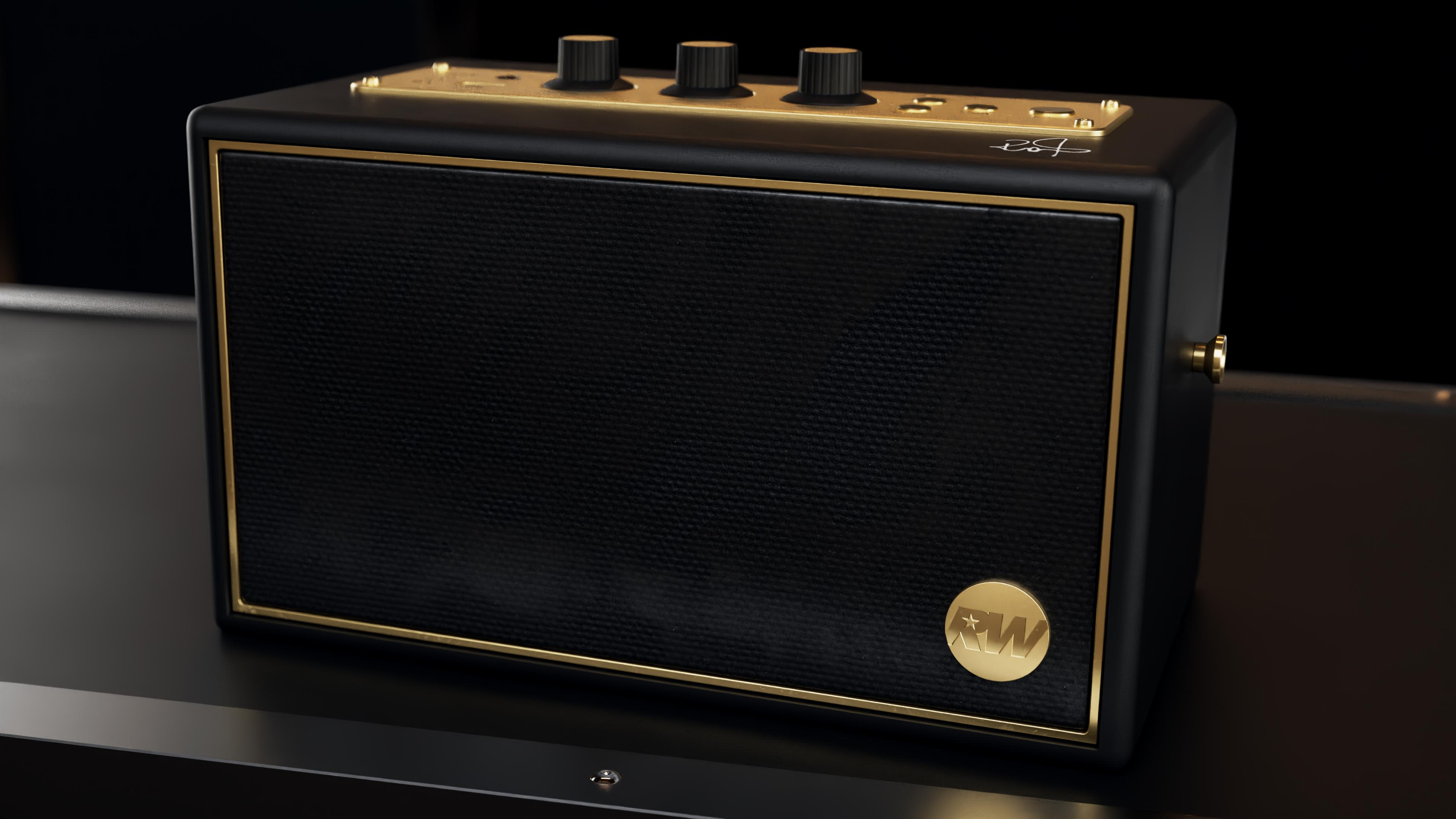 Altavoz negro con detalles dorados, tres perillas y un logo.
