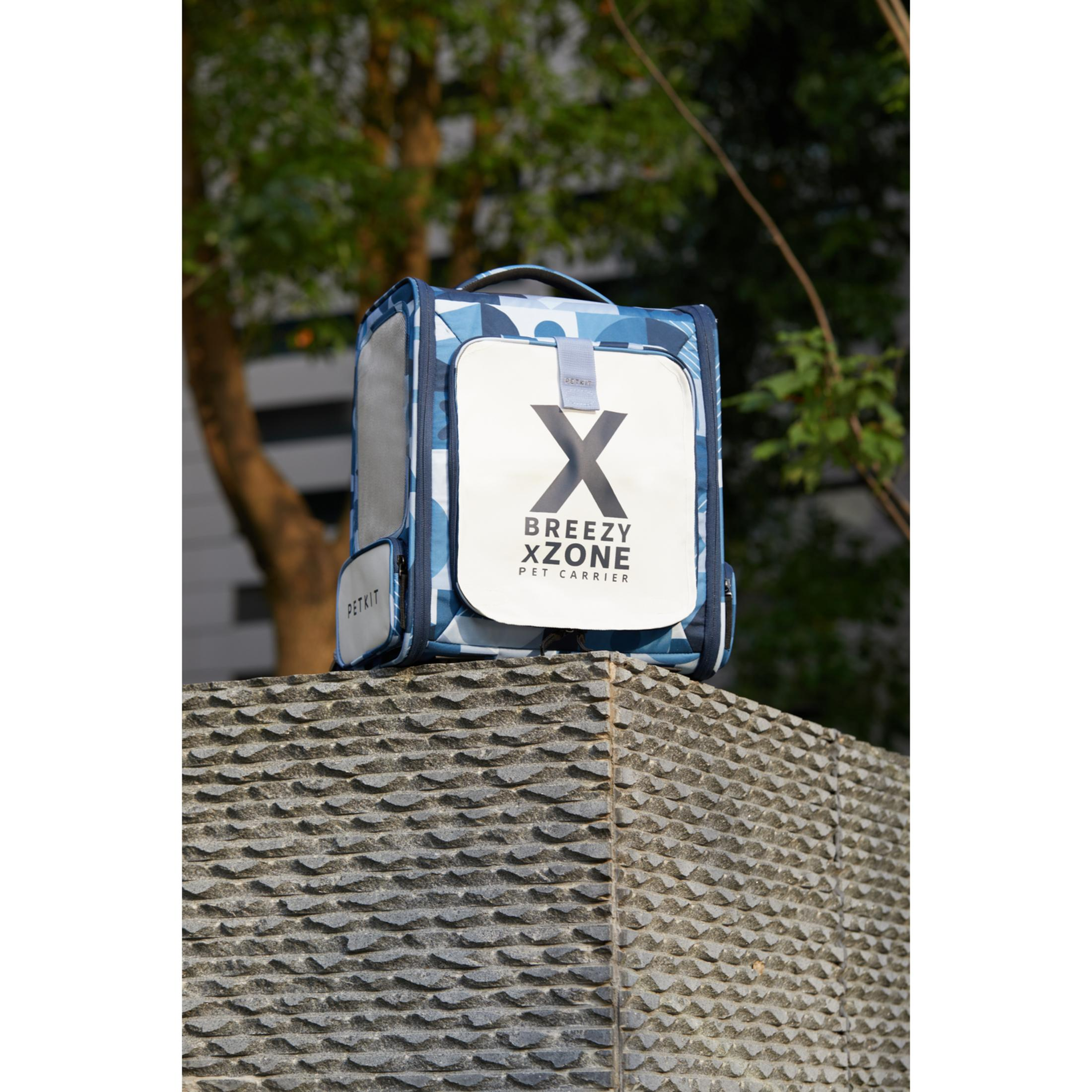 Blue PETKIT pet carrier with geometric pattern on stone.