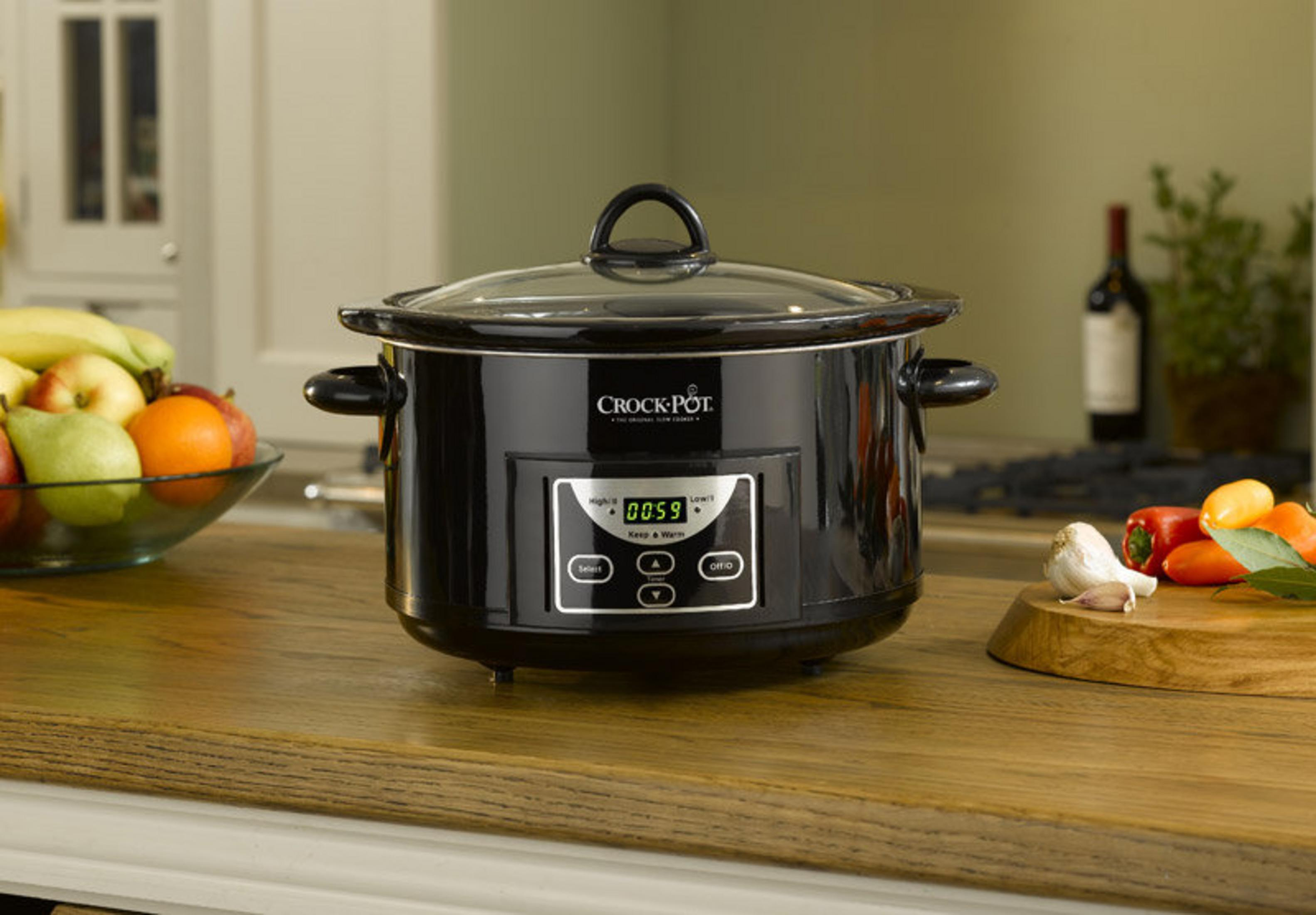 Czarna wolnowar Crock-Pot ze szklaną pokrywką na drewnianej powierzchni.
