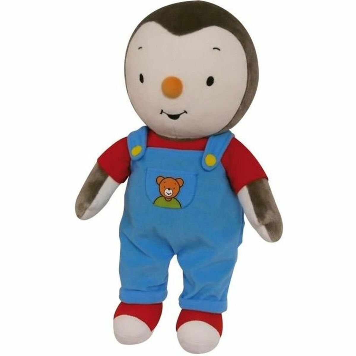 Un peluche di pinguino con salopette blu sopra una maglietta rossa.