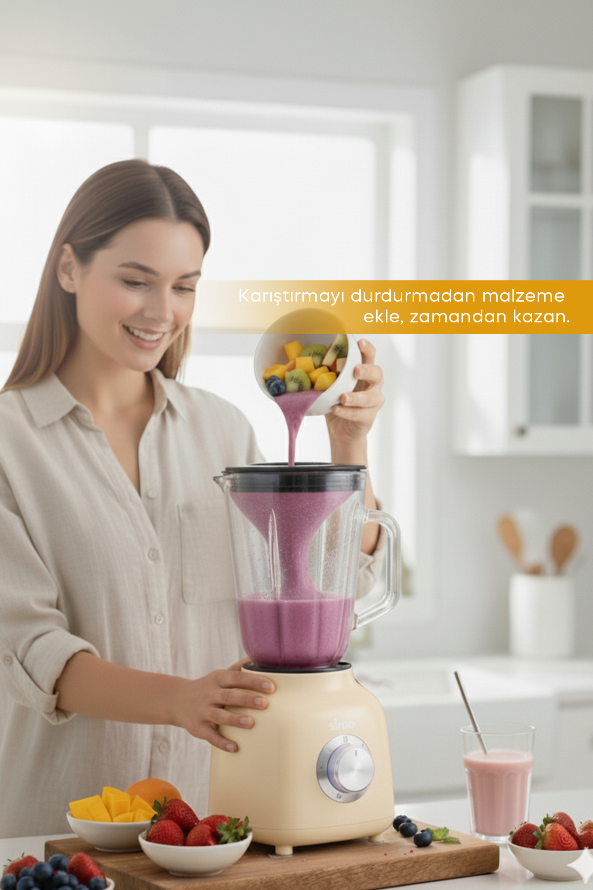 Bir kadın smoothie yapan blendera meyve ekliyor.