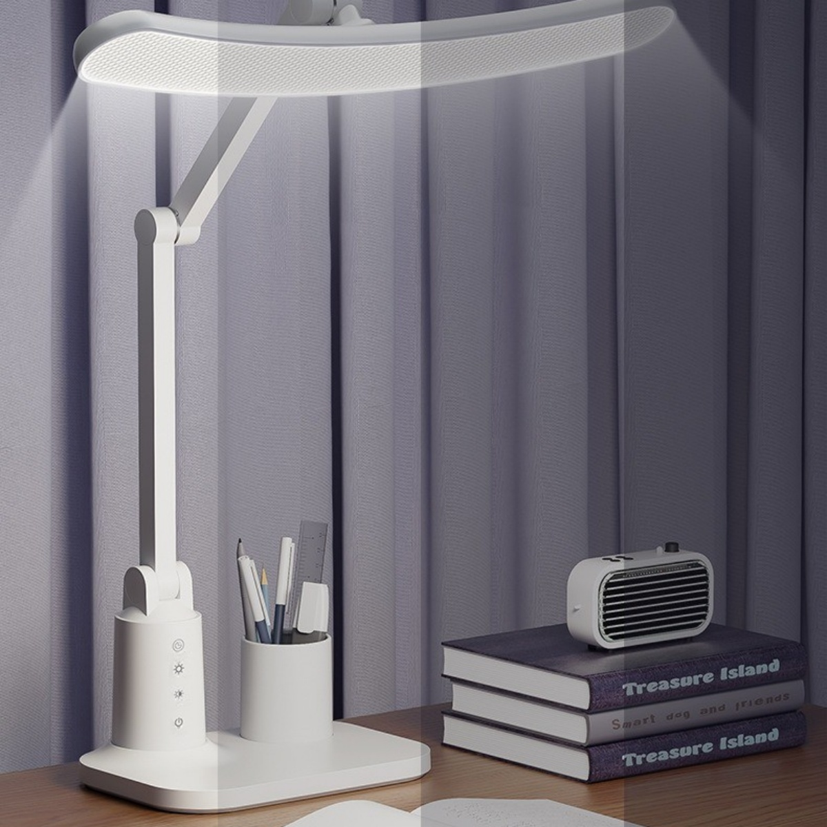 Ein weißer Schreibtischlampen-Halter mit Stiften und Lineal, Bücher und ein kleiner Lüfter.