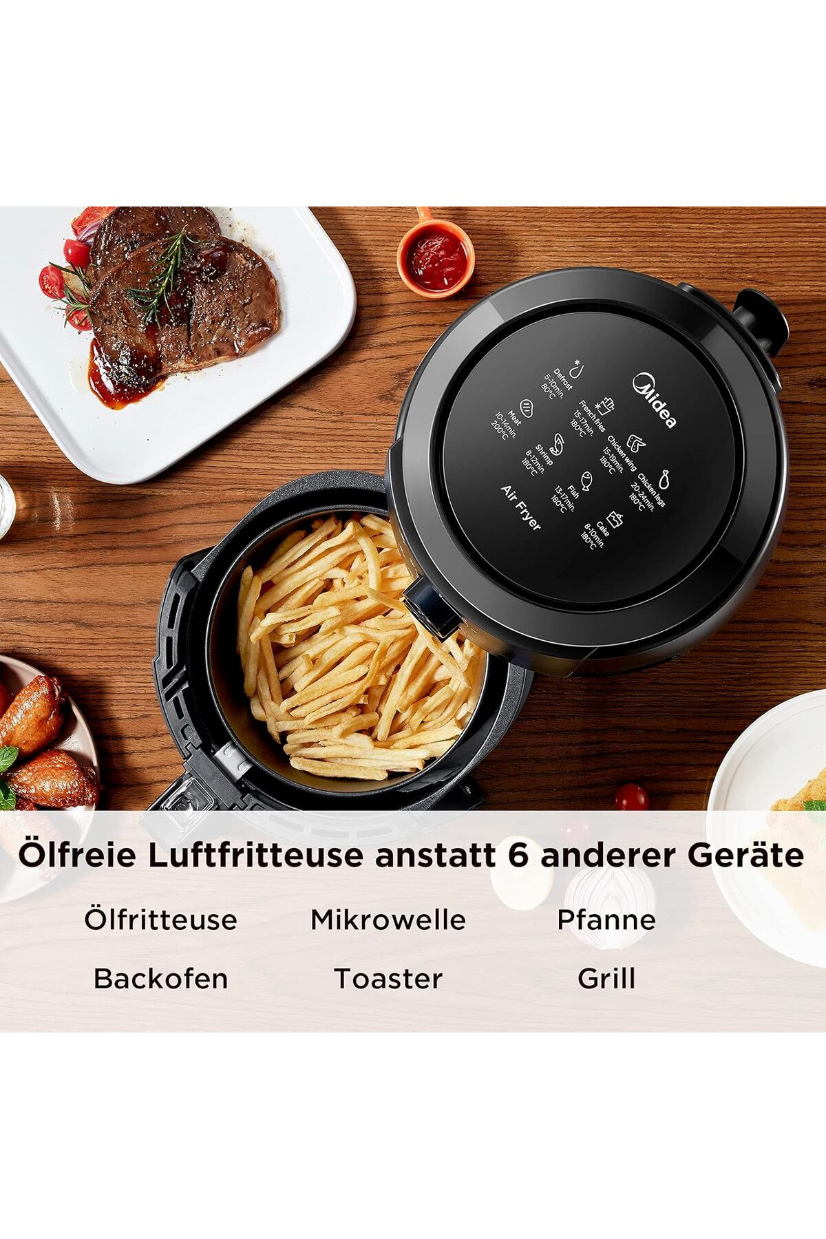 Een zwarte airfryer met frietjes, biefstuk en kippenvleugels.