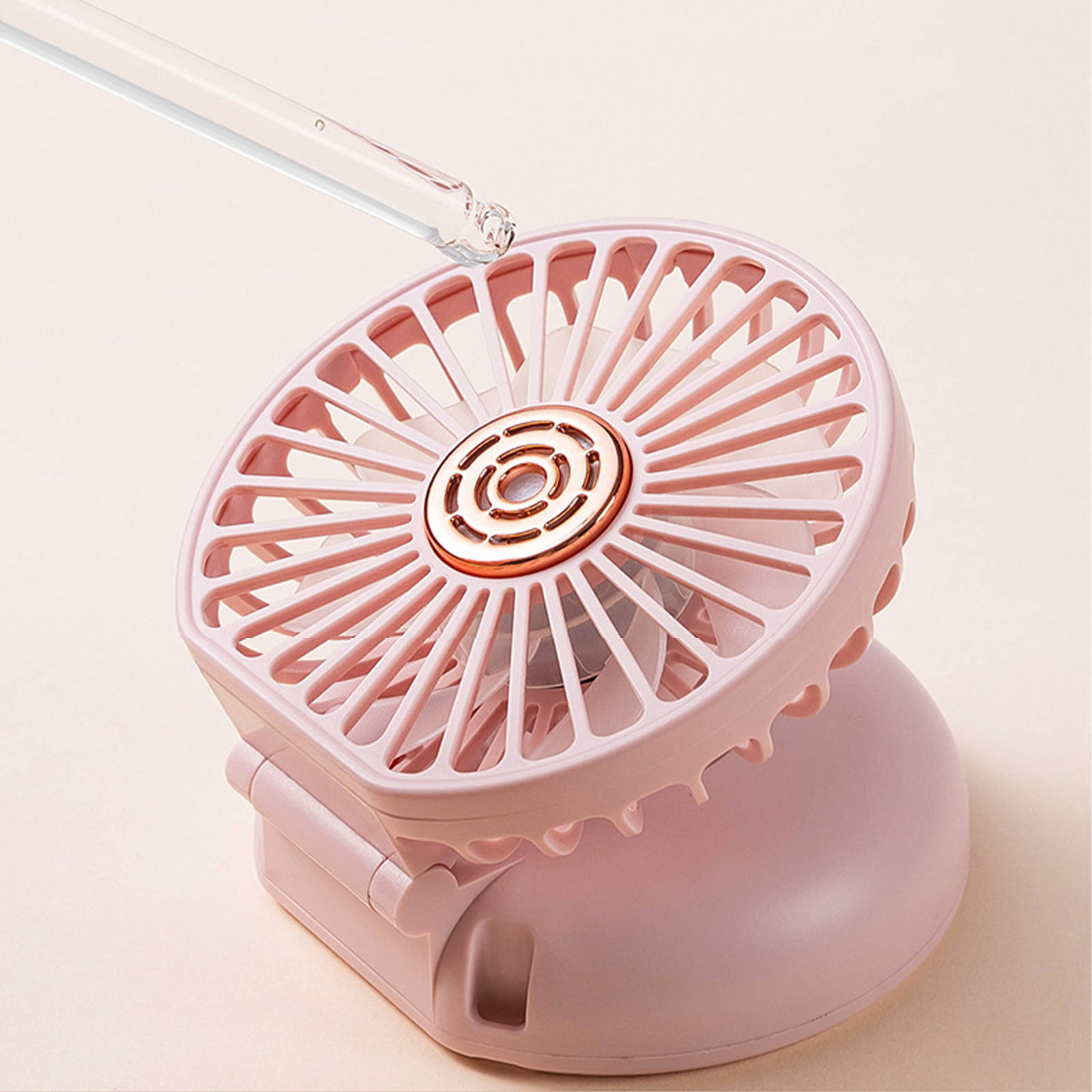 Ein rosafarbener Mini-Ventilator mit einem Pipette, die Tropfen abgibt.