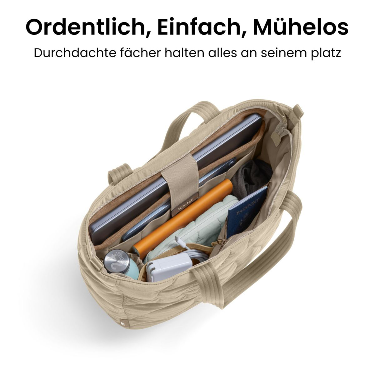 Una borsa tote trapuntata beige con laptop, caricabatterie, passaporto e borraccia.