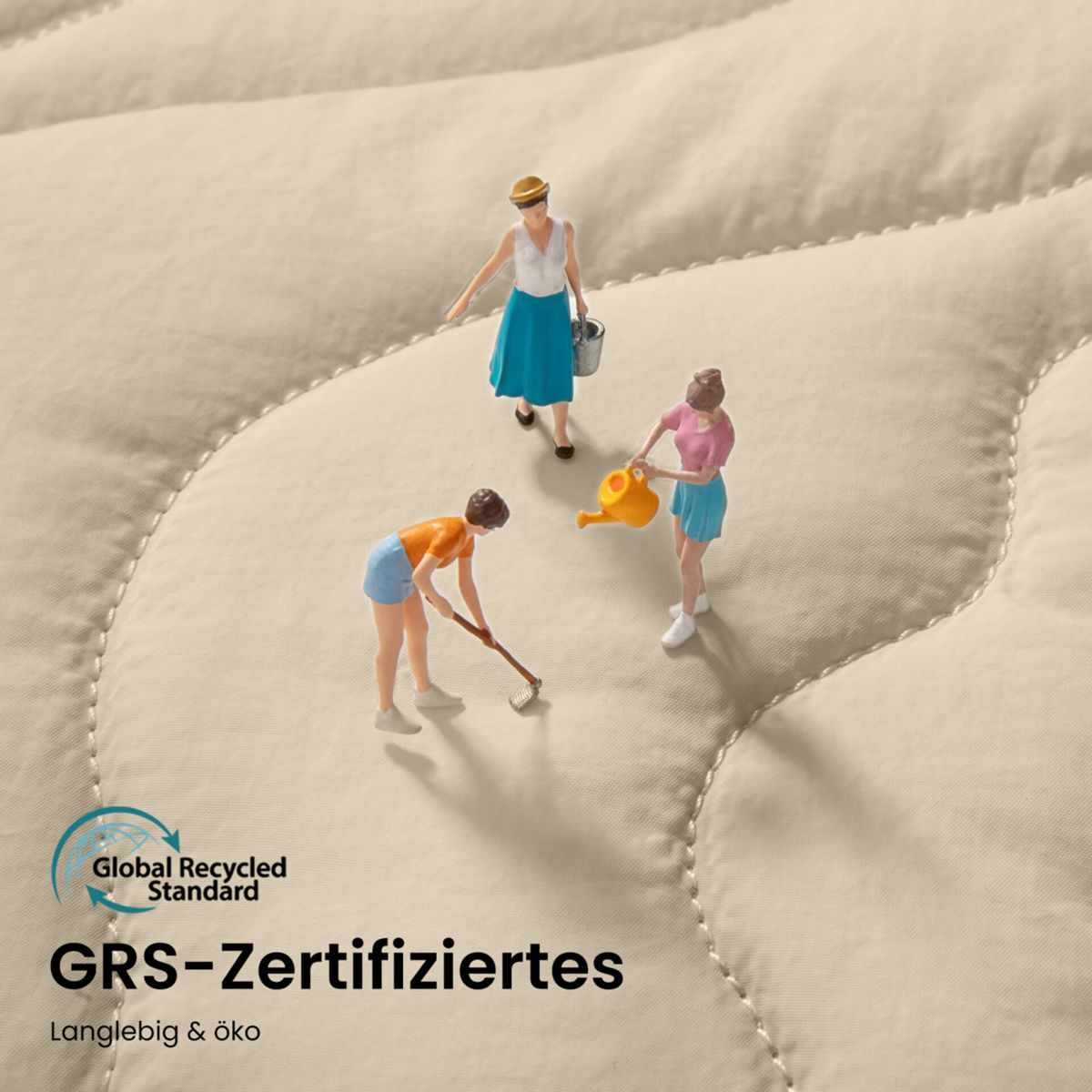 Tre figure in miniatura su una superficie trapuntata color crema. Una annaffia, una zappa, una porta un secchio.