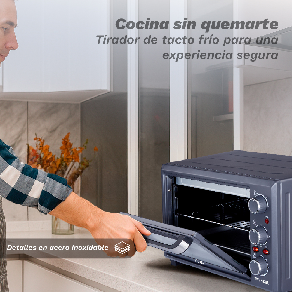 Hombre abre un horno oscuro con tirador frío, detalles en acero inox.
