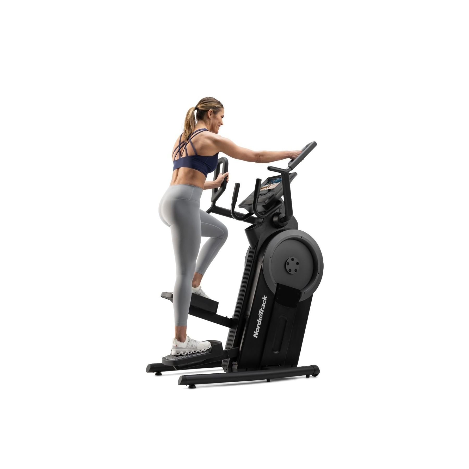 Eine Frau im Fitnessstudio trainiert auf einem schwarzen NordicTrack Stair Climber.