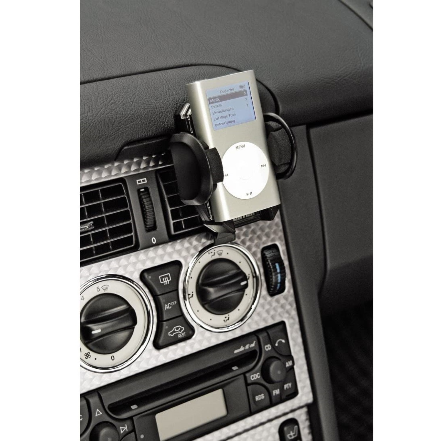 Ein silberner iPod mini ist in einer Autokonsole montiert, neben Klimaanlagenreglern.